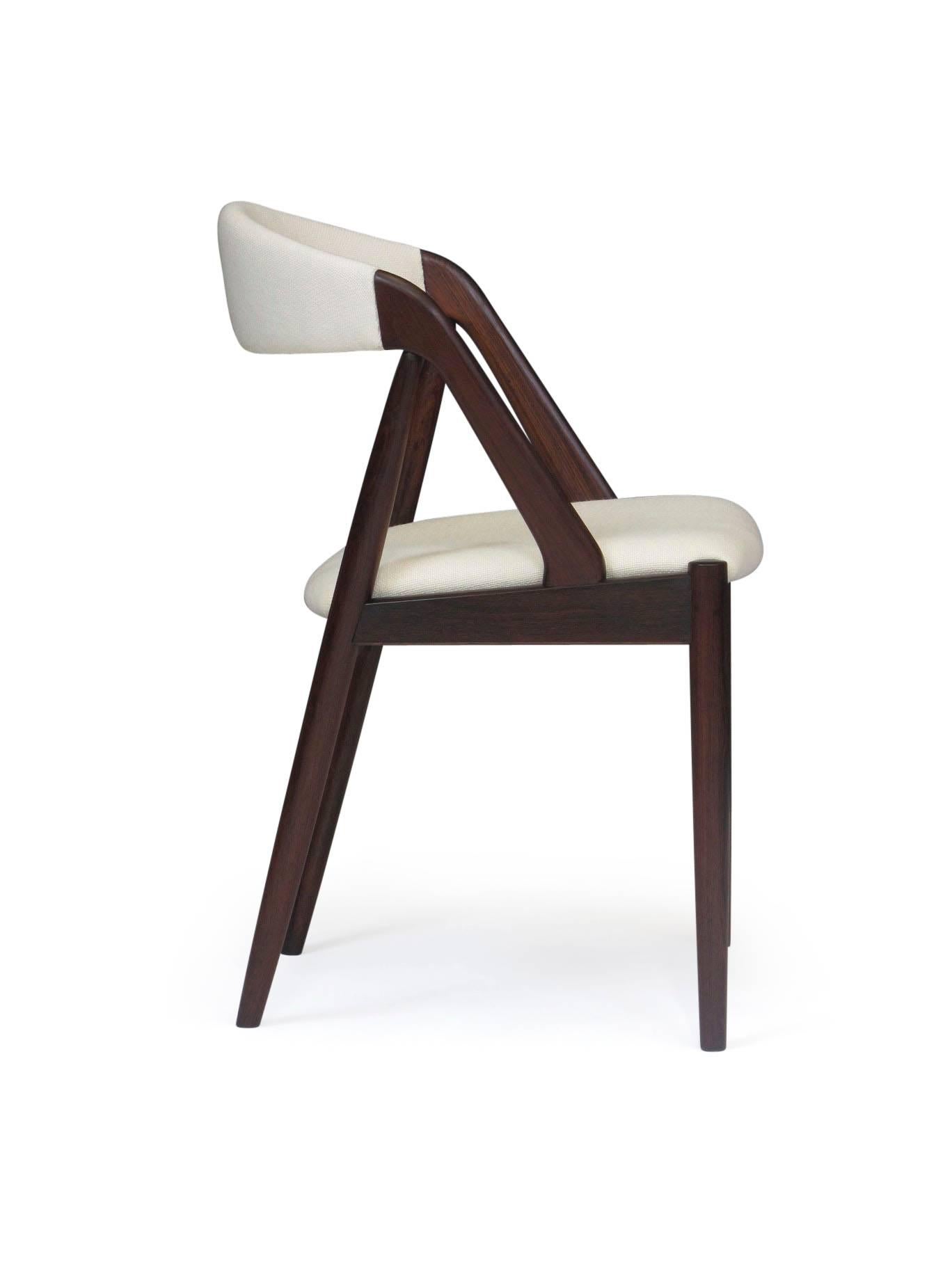 Six mid-century solid Brazilian Rosewood dining chairs designed by Kai Kristiansen. Crafted of solid Brazilian Rosewood frame with comfortable curved backs. Newly upholstered in a Scandinavian off-white wool textile. Professionally restored, the