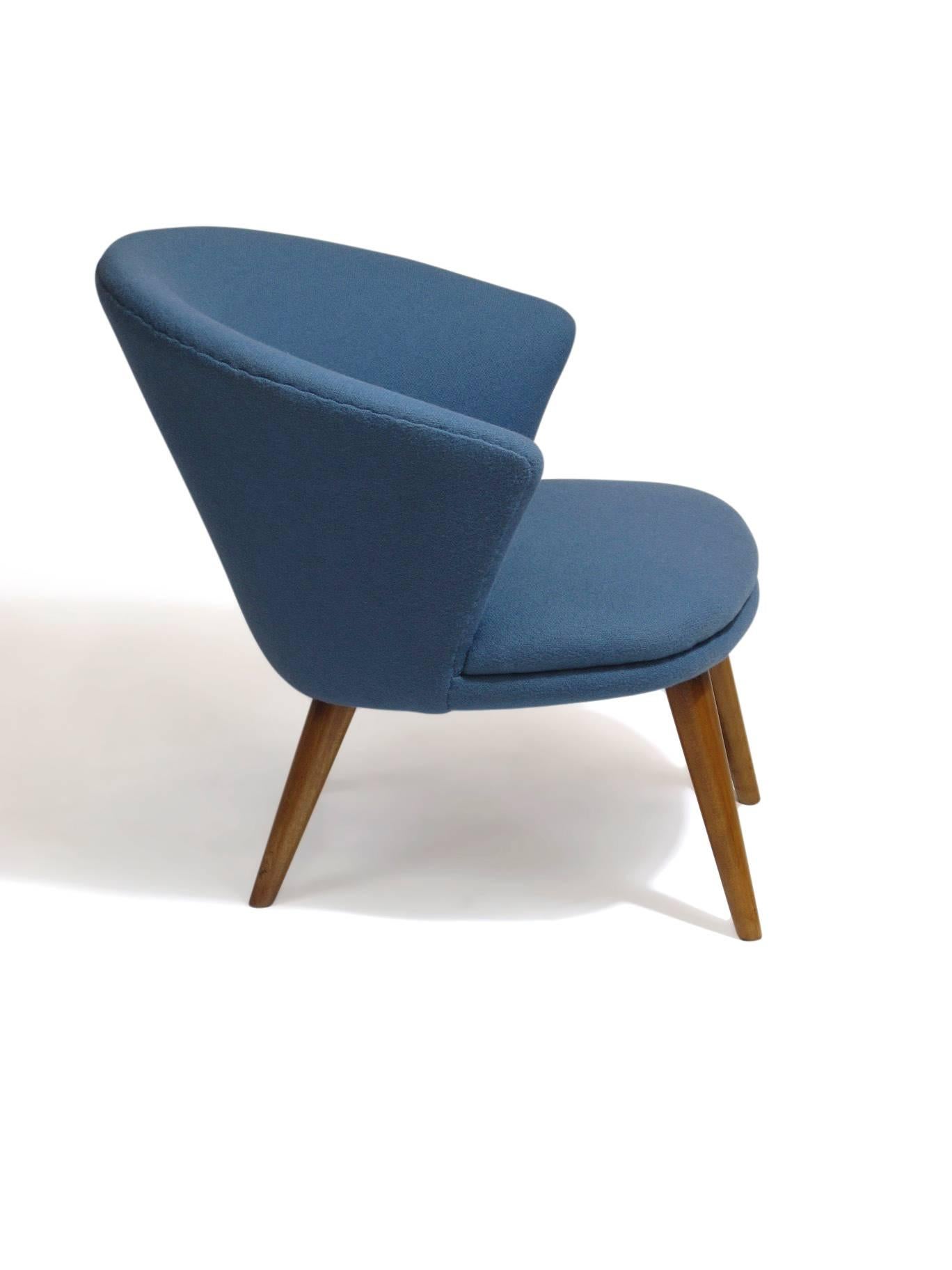 Danish lounge chair with comfortable curved back raised on tapered beech legs newly upholstered in period accurate blue wool textile.
 
