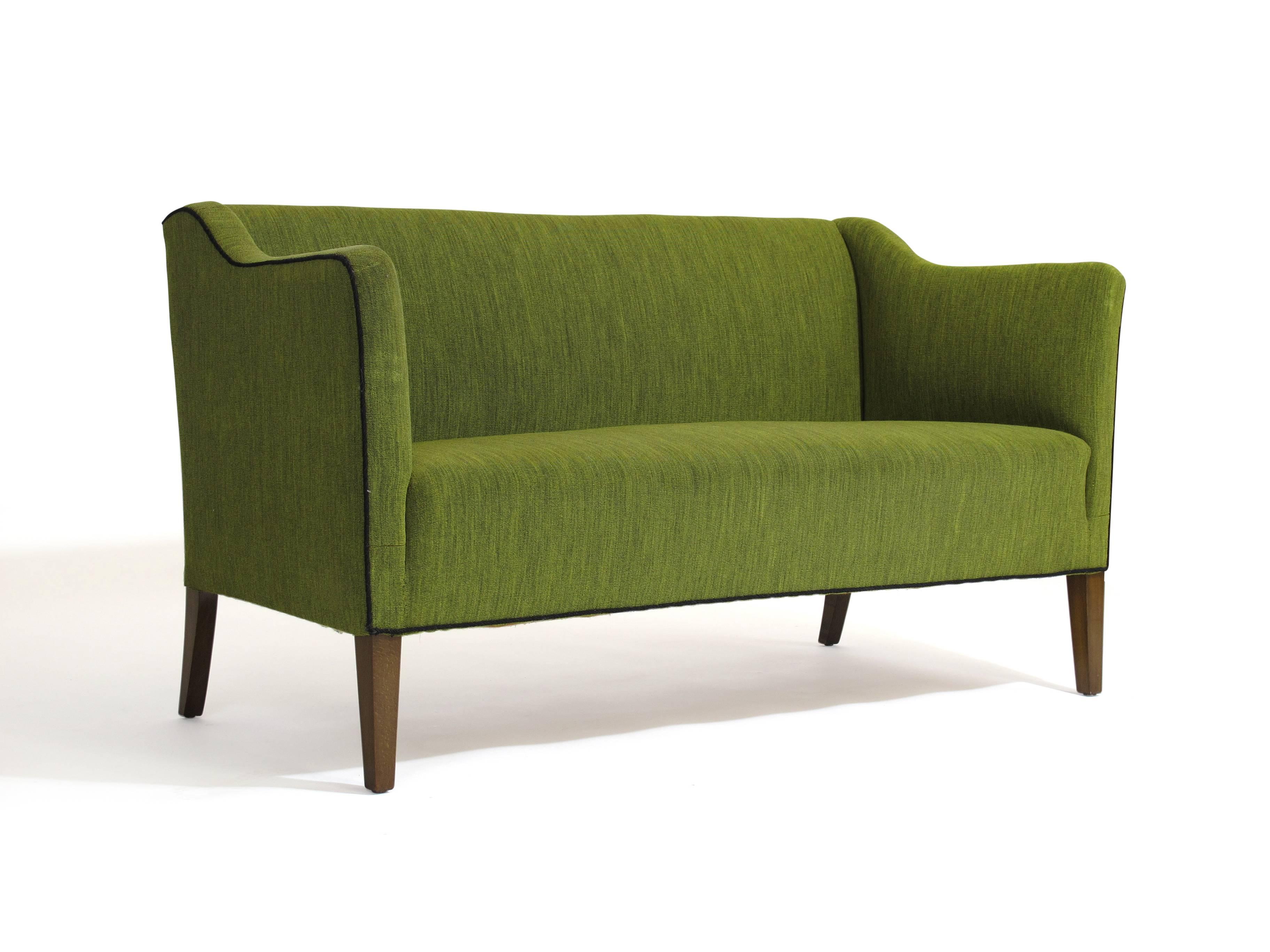 Danish loveseat settee constructed of a high-quality solid wood frame with hand-tied copper springs seat support, upholstered in the original green wool woven fabric. Raised on walnut stained beech legs, circa 1940.