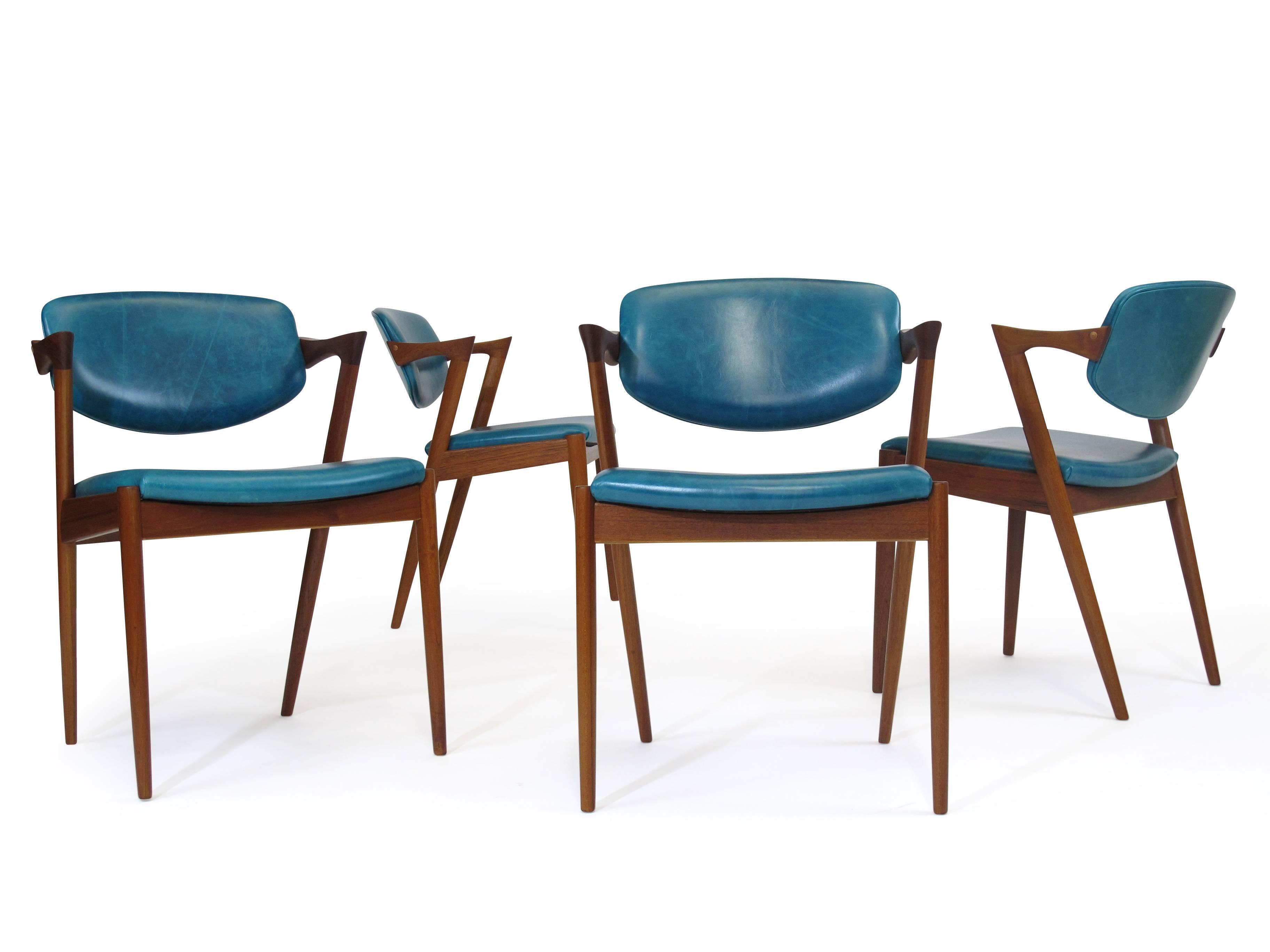 Six Kai Kristiansen model 42 teak dining chairs manufactured by V. Schou Andersen, circa 1964. The chairs features solid teak frames with tilt back rests and angles arms. The chairs have been professionally restored and upholstered in top-quality