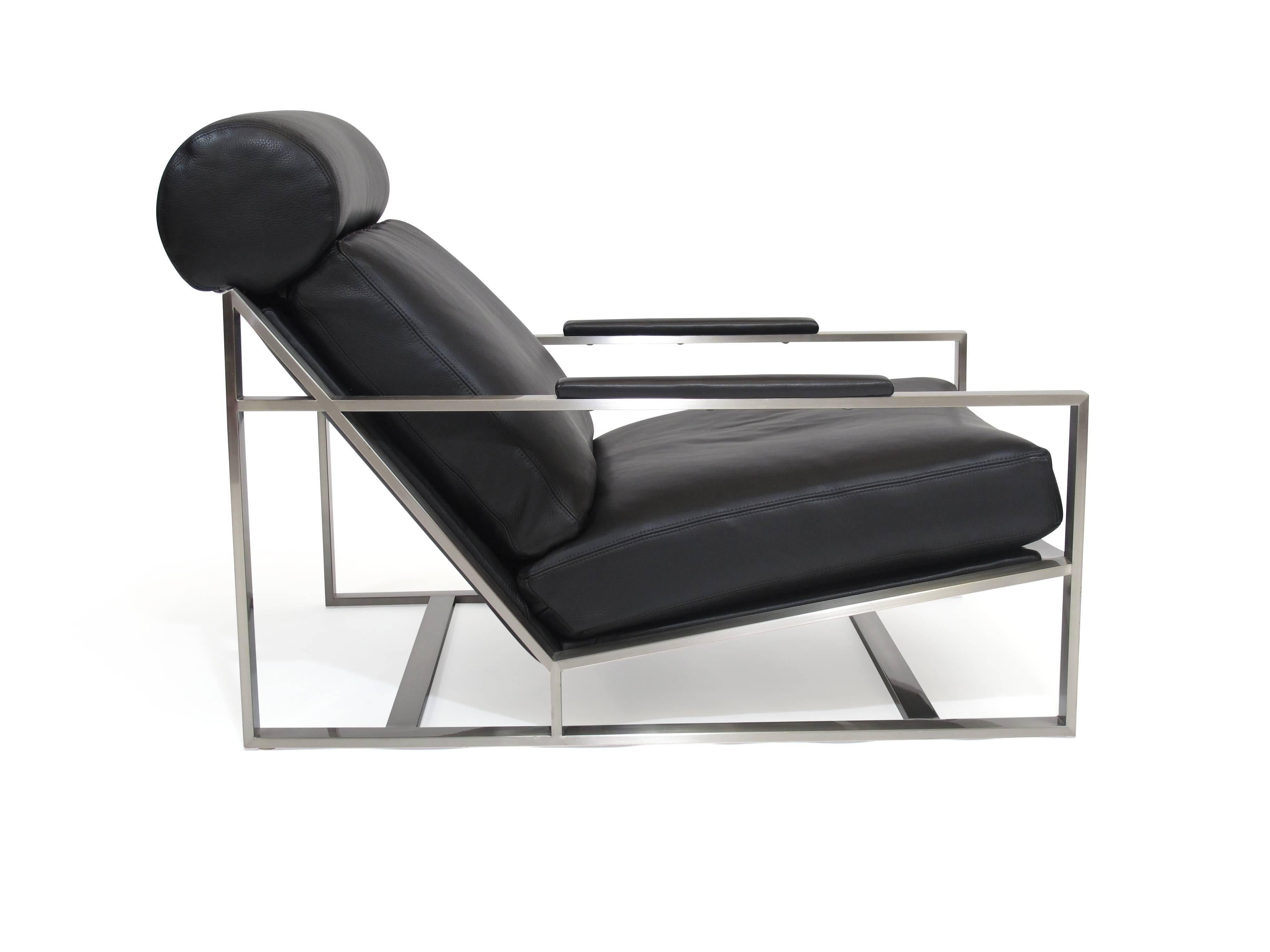 Lounge chair designed by Milo Baughman for Thayer Coggin, circa 1965.
Low, comfortable lounge chair with reclined back and head cushion, upholstered in fine black leather with double top-stitching on a brushed stainless steel frame. Label. Ottoman: