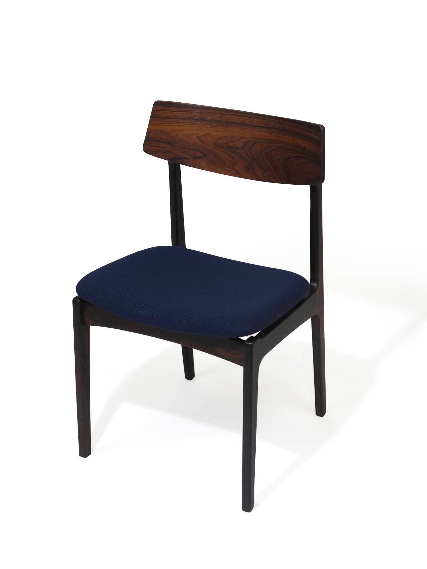 Set of four sturdy rosewood dining chairs with curved backs and newly upholstered in navy Danish wool.