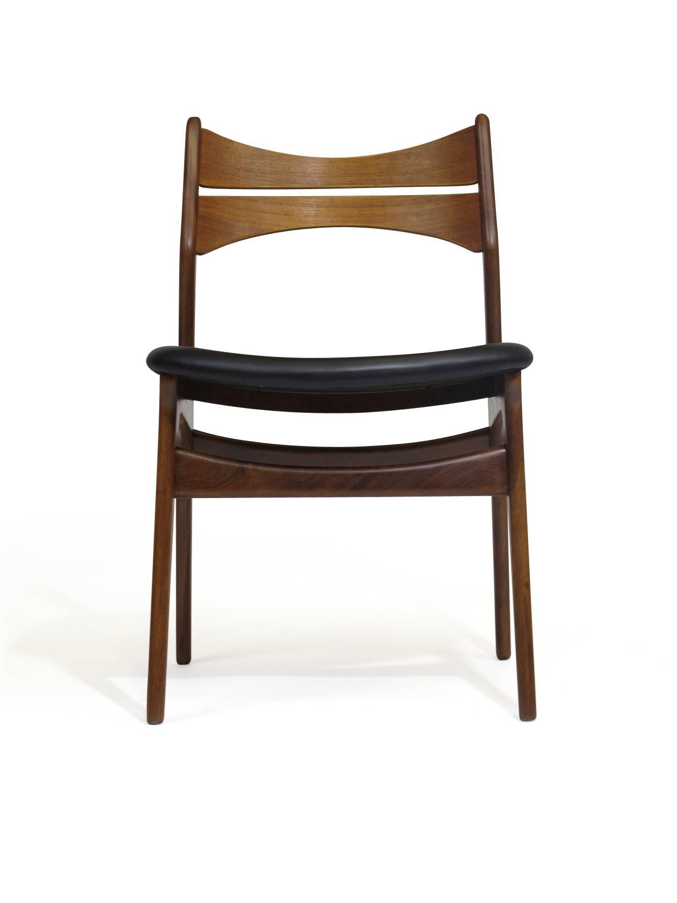 Six Eric Buck dining chairs designed in 1961, crafted of solid teak with comfortable backrest, finely restored and upholstered in new black leather. Up to 45 chairs available for custom upholstery. 