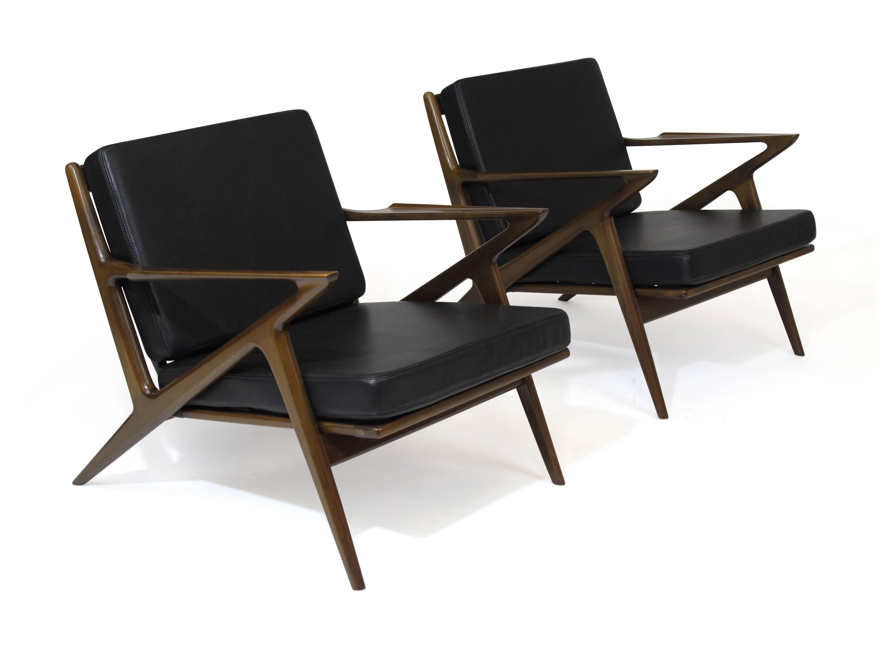 Pair of Selig 'Z' lounges design by Poul Jensen. Walnut stained beechwood, original wood finished cleaned and polished, with newly upholstered cushions in black leather over new rubber straps.