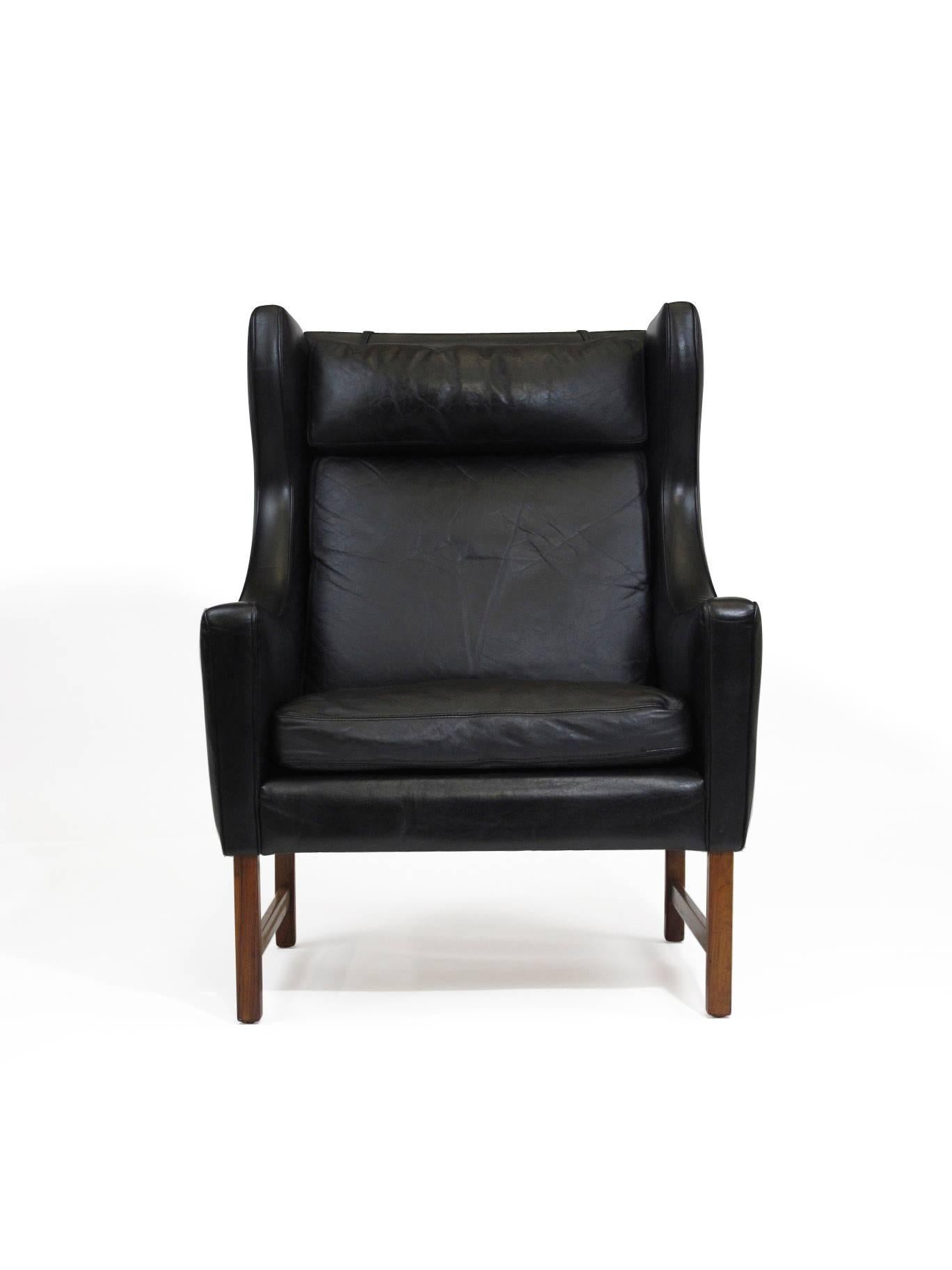 Midcentury highback lounge chair designed by Fredrik Kayser for Vatne Møbler, Norway, circa 1964. Solid wood frame upholstered in the original black leather, raised on rosewood legs. Matching ottoman available upon request.
