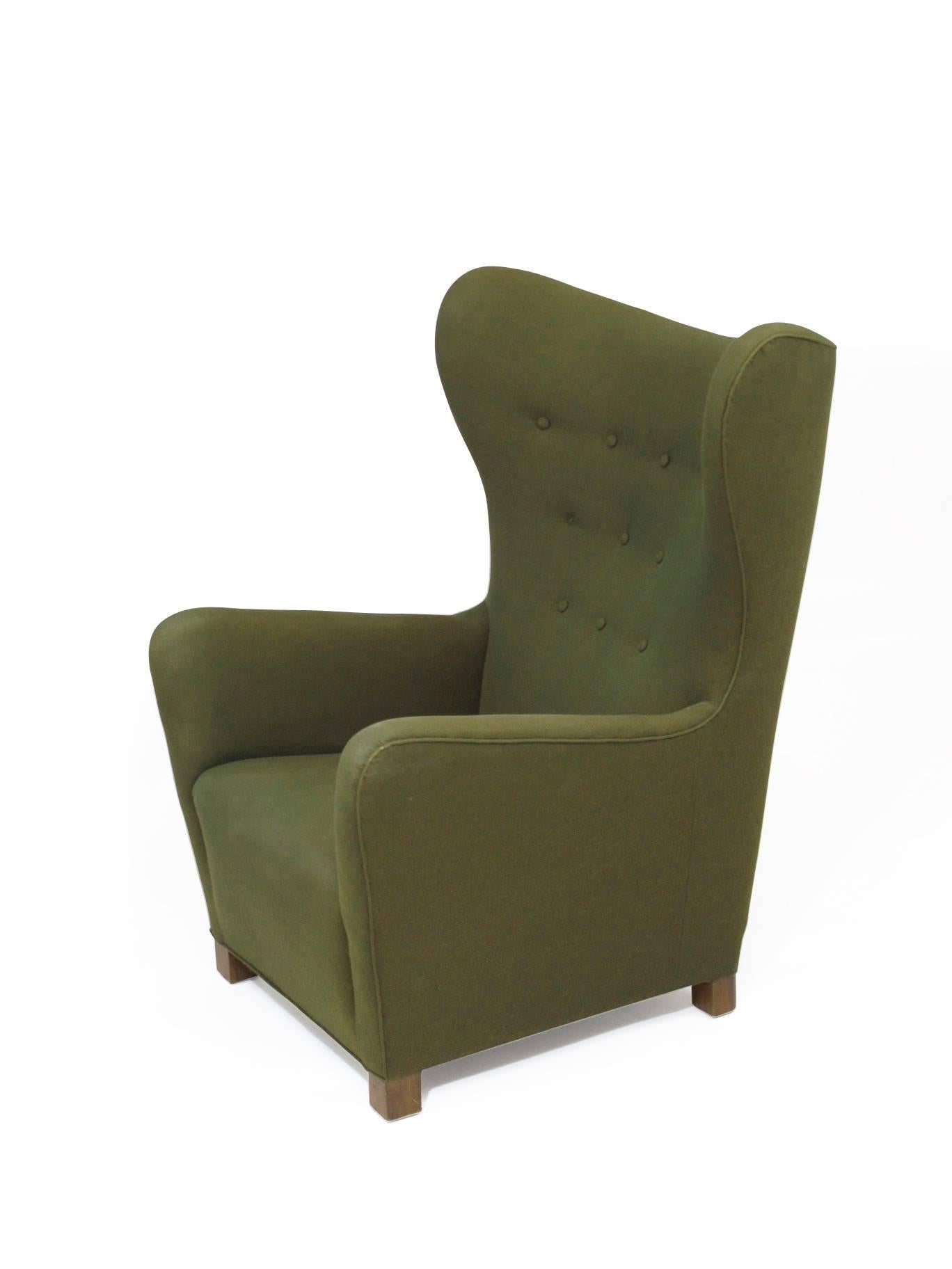 Chris Howard Antiques & Modern presents this early midcentury Danish high back lounge chair handcrafted at Fritz Hansen, circa 1942. Features a solid wood frame, with copper coil springs and horsehair padding covered in the original green wool