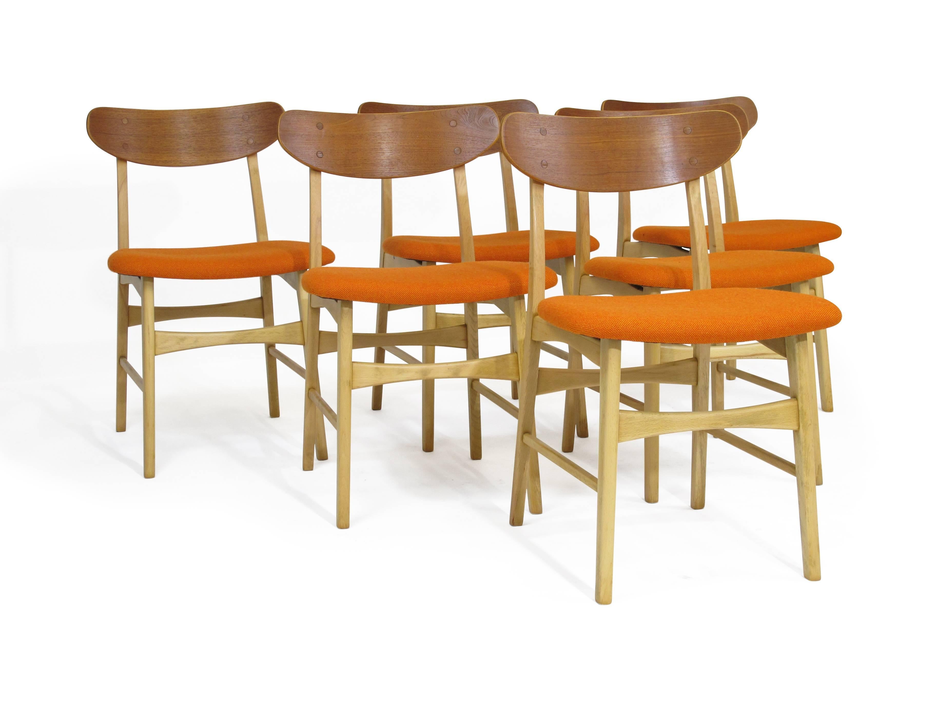 Midcentury dining chairs crafted with a solid beech frames and teak backrest. Fully restored to enhance the natural wood tones. Newly upholstered seats in a orange wool textile.