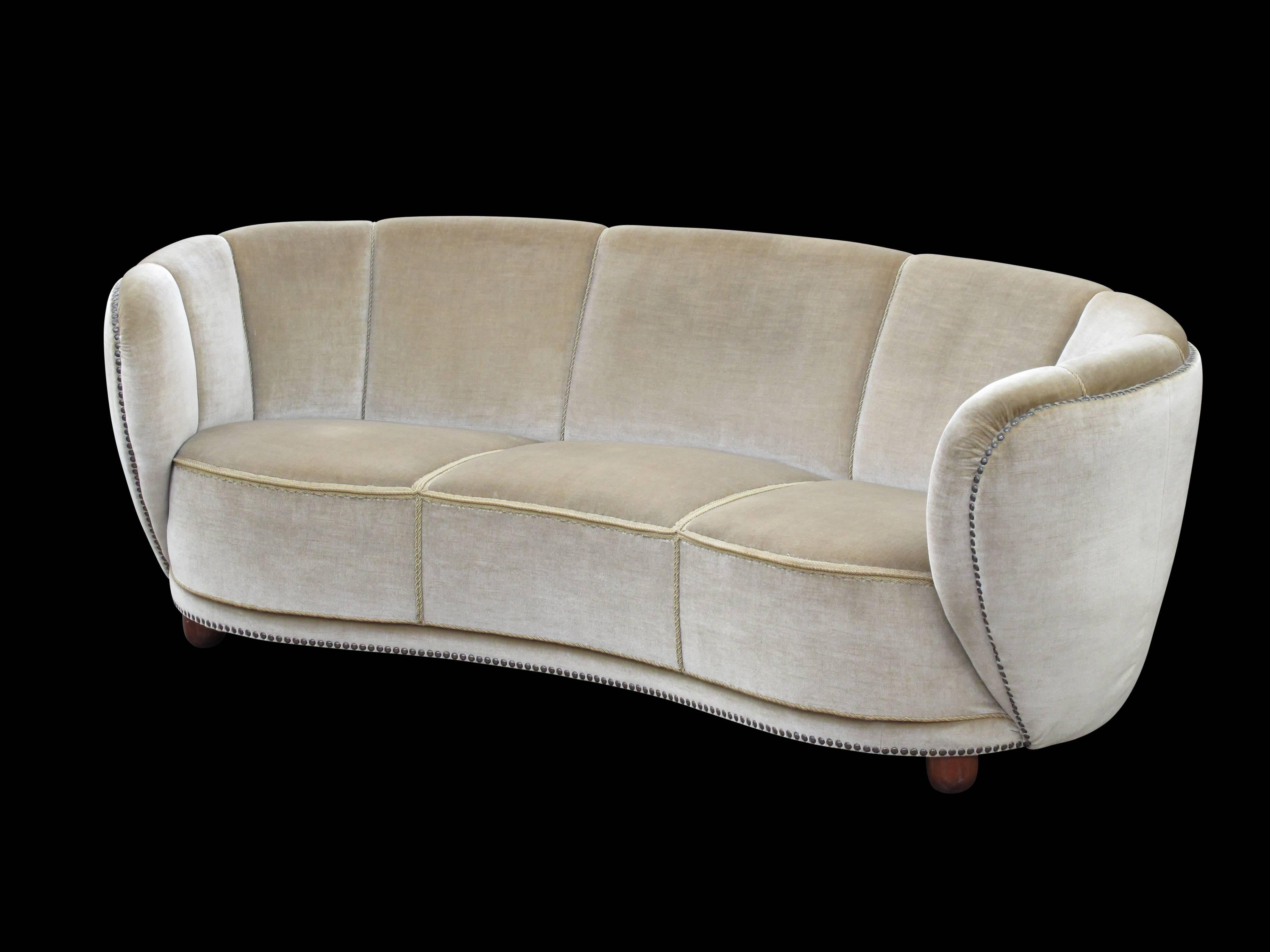Early 1930s curved back sofa in the original mohair fabric with brass tacks along outer edge, eight-way hand tied springs on solid constructed frame. Excellent original condition.