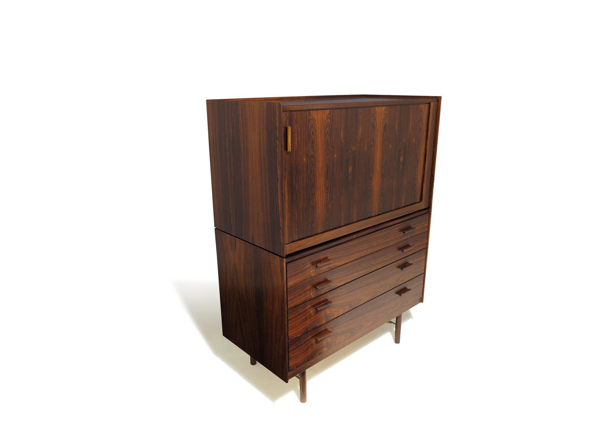 A finely crafted mid-century Danish cabinet designed by Ib Kofod-Larsen for Brande Møbelfabrik, Denmark, 1958. The piece features a lower section with four drawers, each with sculpted pulls and birch interiors, and an upper hutch with tambour doors