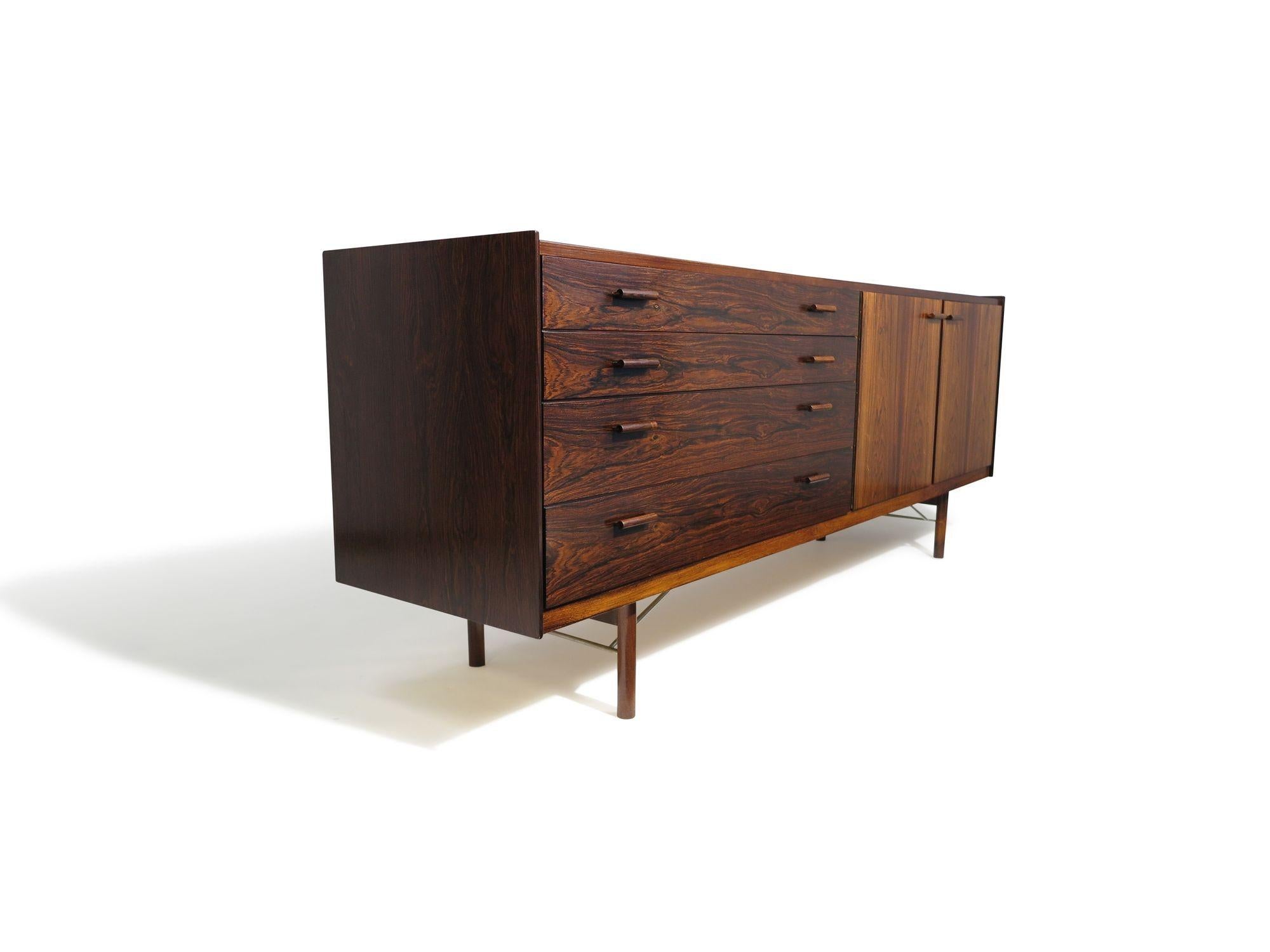 Credenza danese di metà secolo finemente lavorata, disegnata da Ib Kofod-Larsen per Brande Møbelfabrik, Danimarca, 1958. Finemente realizzata in palissandro brasiliano di vecchia crescita, la credenza presenta un bordo rialzato, uno schienale