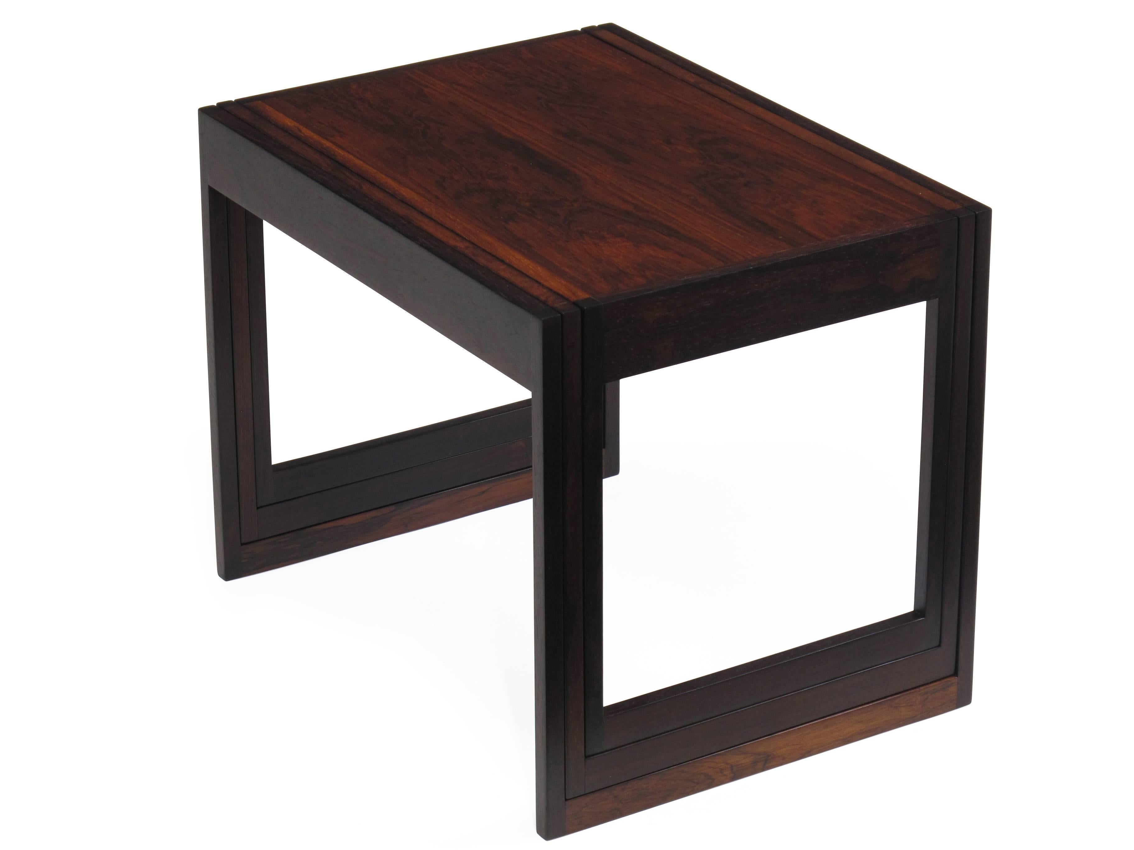 Rare set of three rosewood nesting tables produced by CF Christensen of Silkeborg, Denmark. Vertical nesting system with exquisite craftsmanship. The innovative drop in design allows the tables to rest in a slim profile while nested. Dark rosewood,