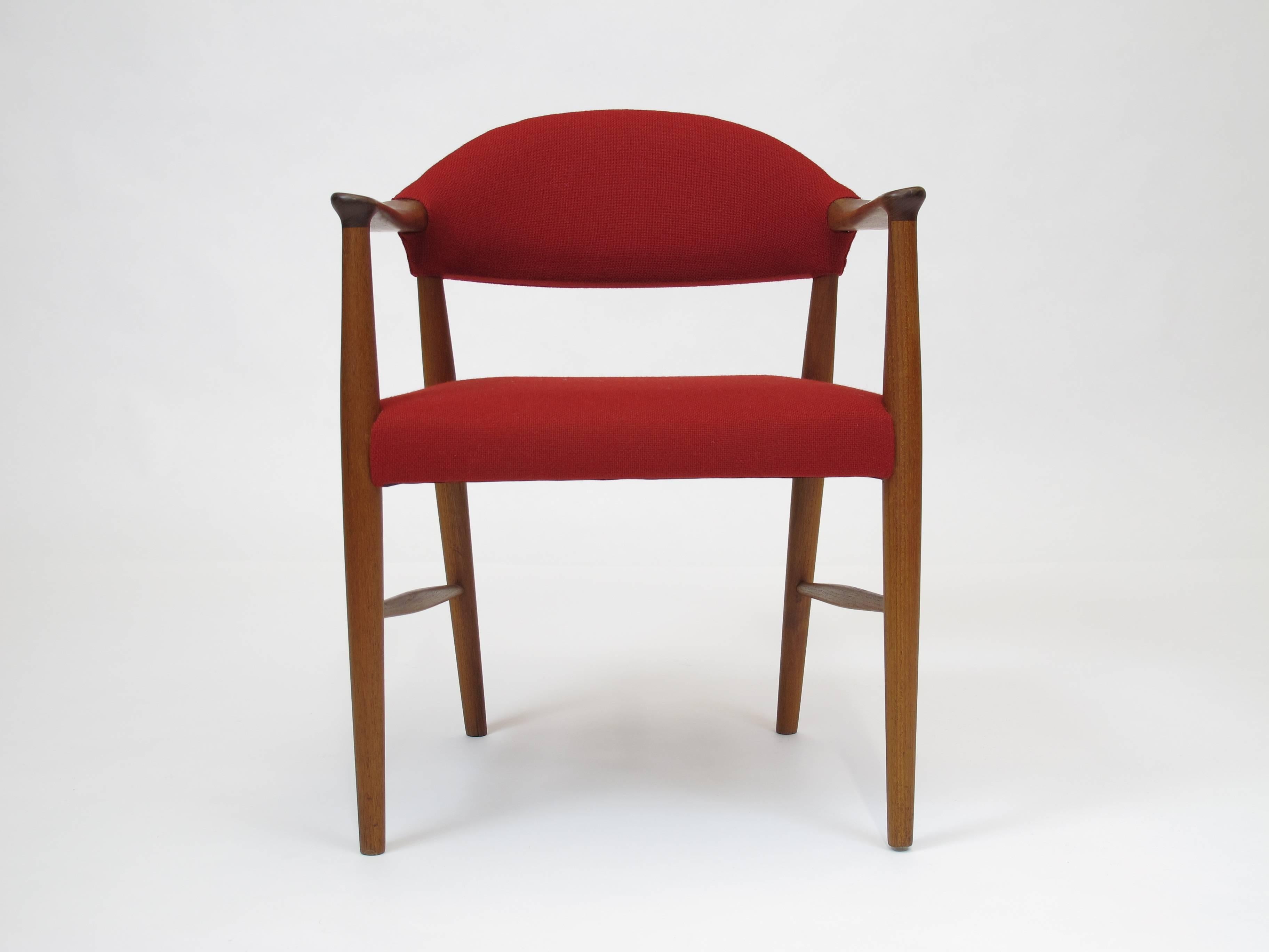 Pair of mid-century teak armchairs designed by Kurt Olsen.  Newly upholstered in a Scandinavian red wool textile. Seat constructed of rubber stamps covered in foam and fabric. Fabric sample available upon request.