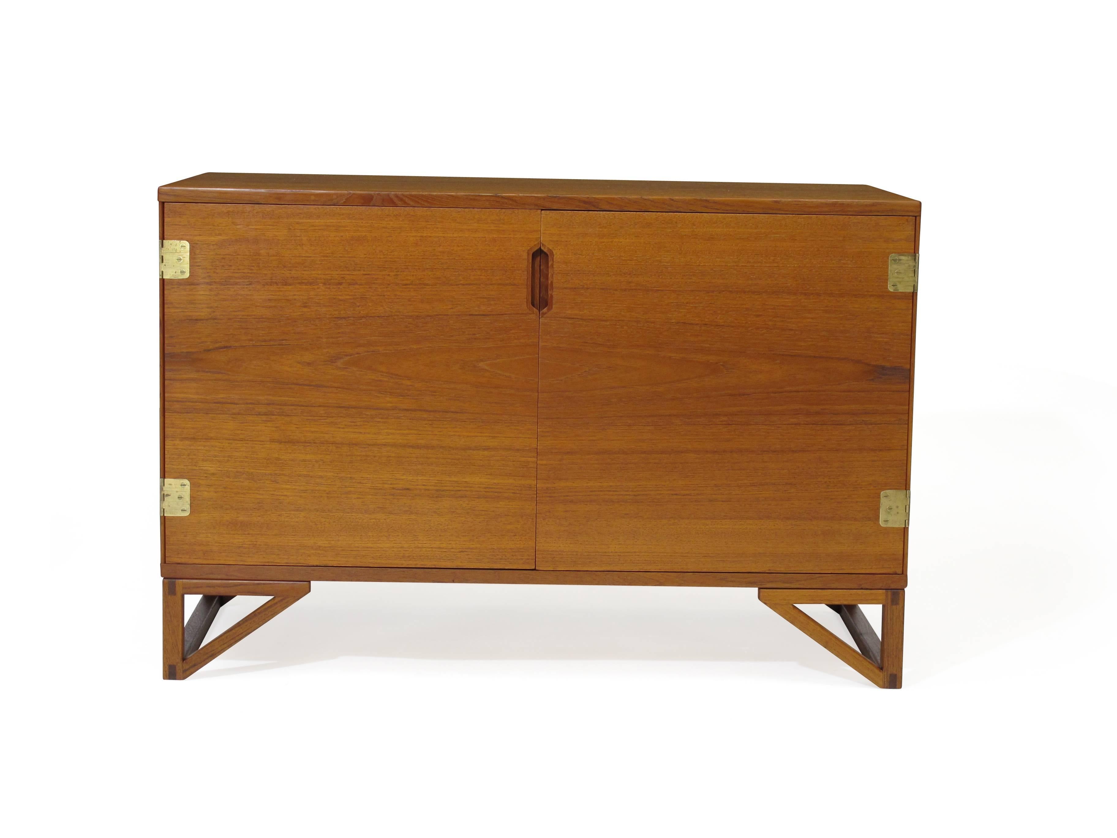 Matching pair of finely crafted teak cabinets designed by Svend Langkilde. One cabinet with doors and series of silverware drawers and adjustable shelf, second cabinet with four drawers.