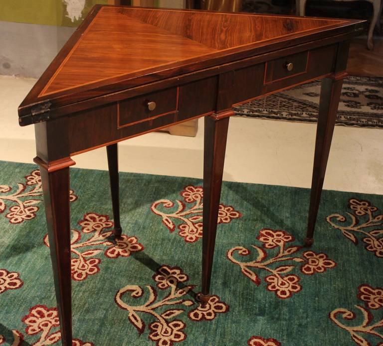Cette magnifique table de jeu pliante d'époque Louis XVI, de haute qualité et d'origine italienne, est fabriquée en bois précieux. Le bois de tulipe, le bois de roi et l'acajou alternent dans les incrustations pour créer d'élégants effets