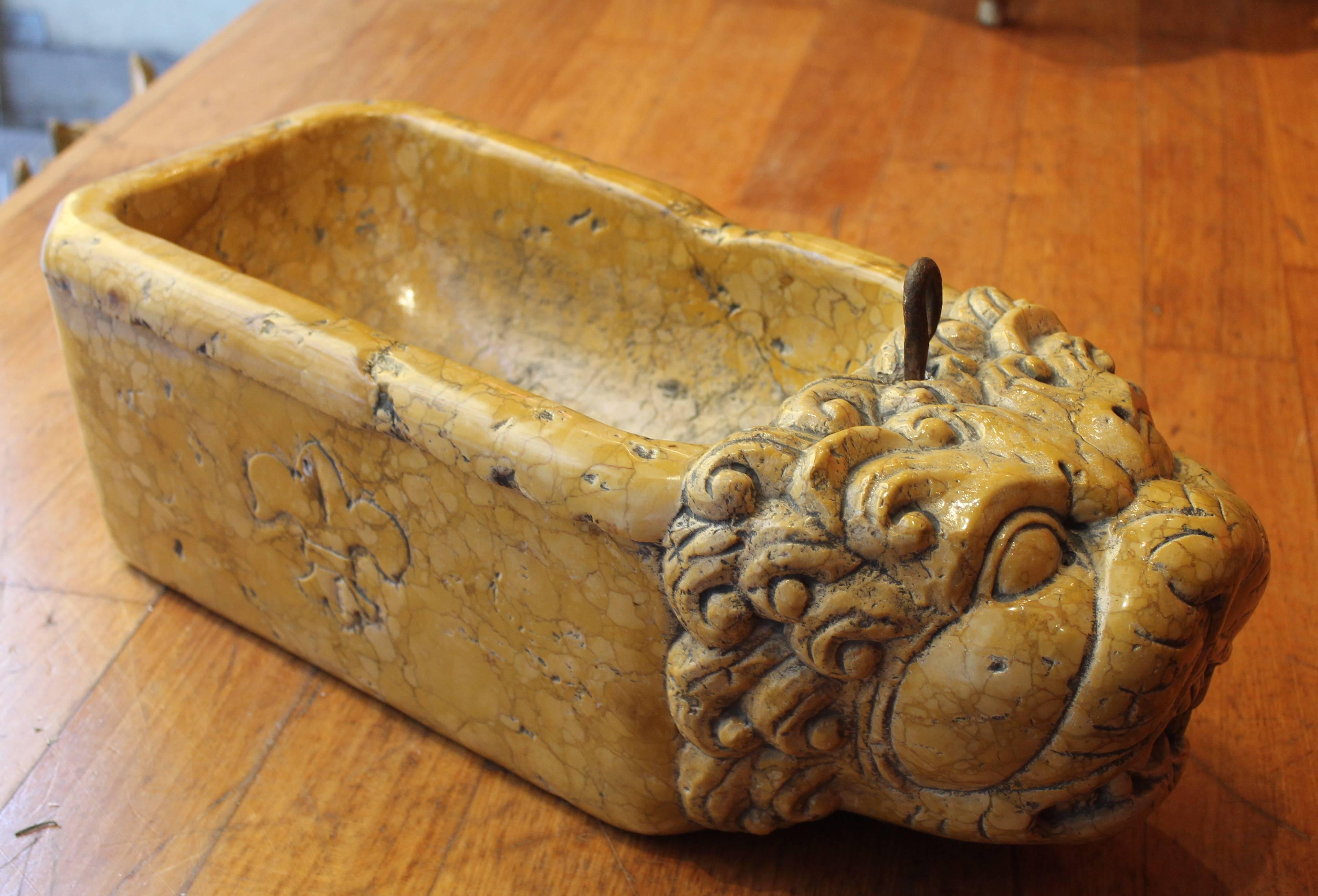 A late 18th Century wonderfully carved yellow Sienna marble fountain with lion head in beautifully aged condition. The lion has a highly articulate mane and a lively facial expression. A beautiful Fleur-de-lis, symbol of the city of Florence, is