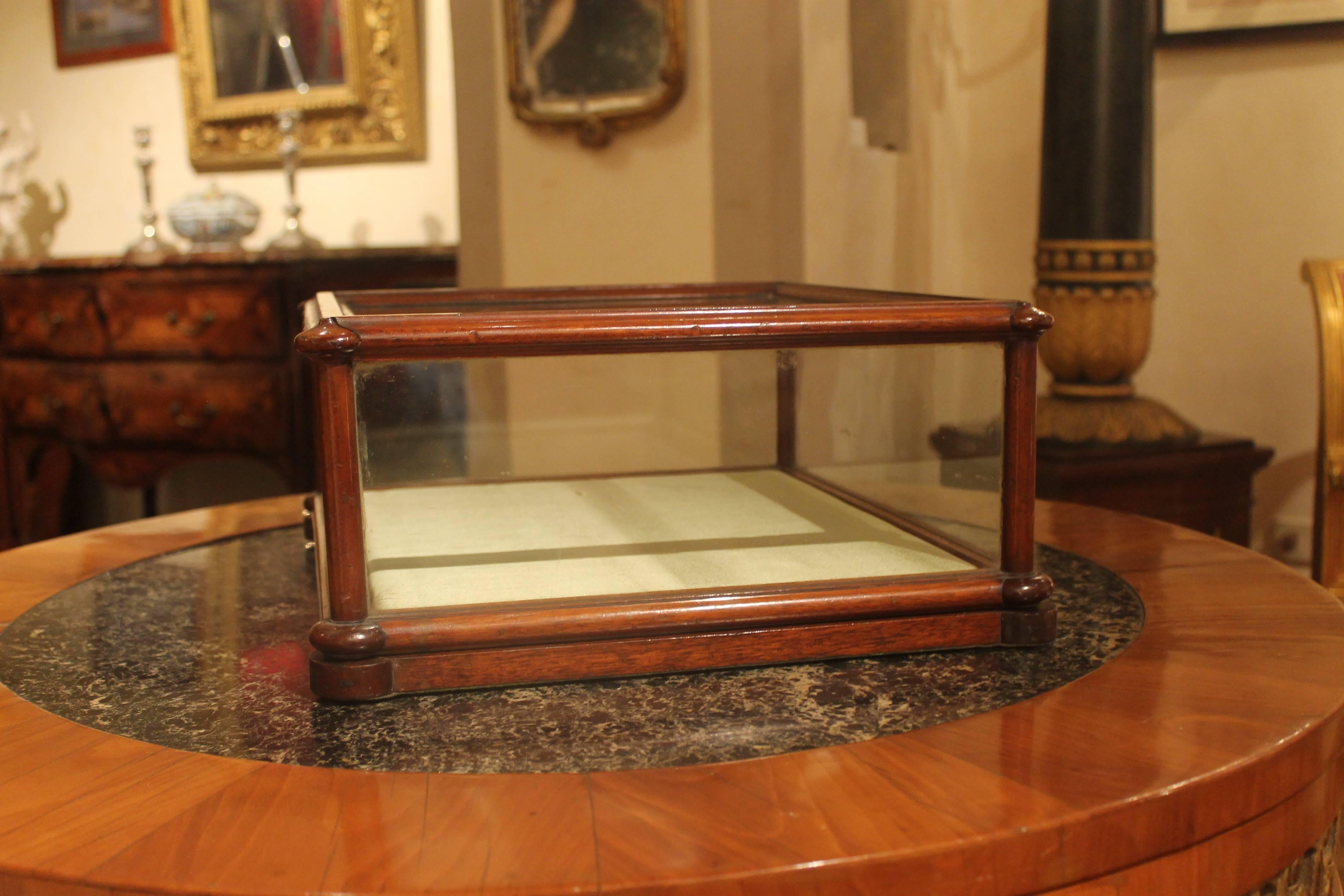 This English 19th century antique rectangular table cabinet display case or showcase of narrow proportions has a mahogany moulding frame throughout, the top and the sides are glazed with the original excellent thick glasses. The wood base is covered