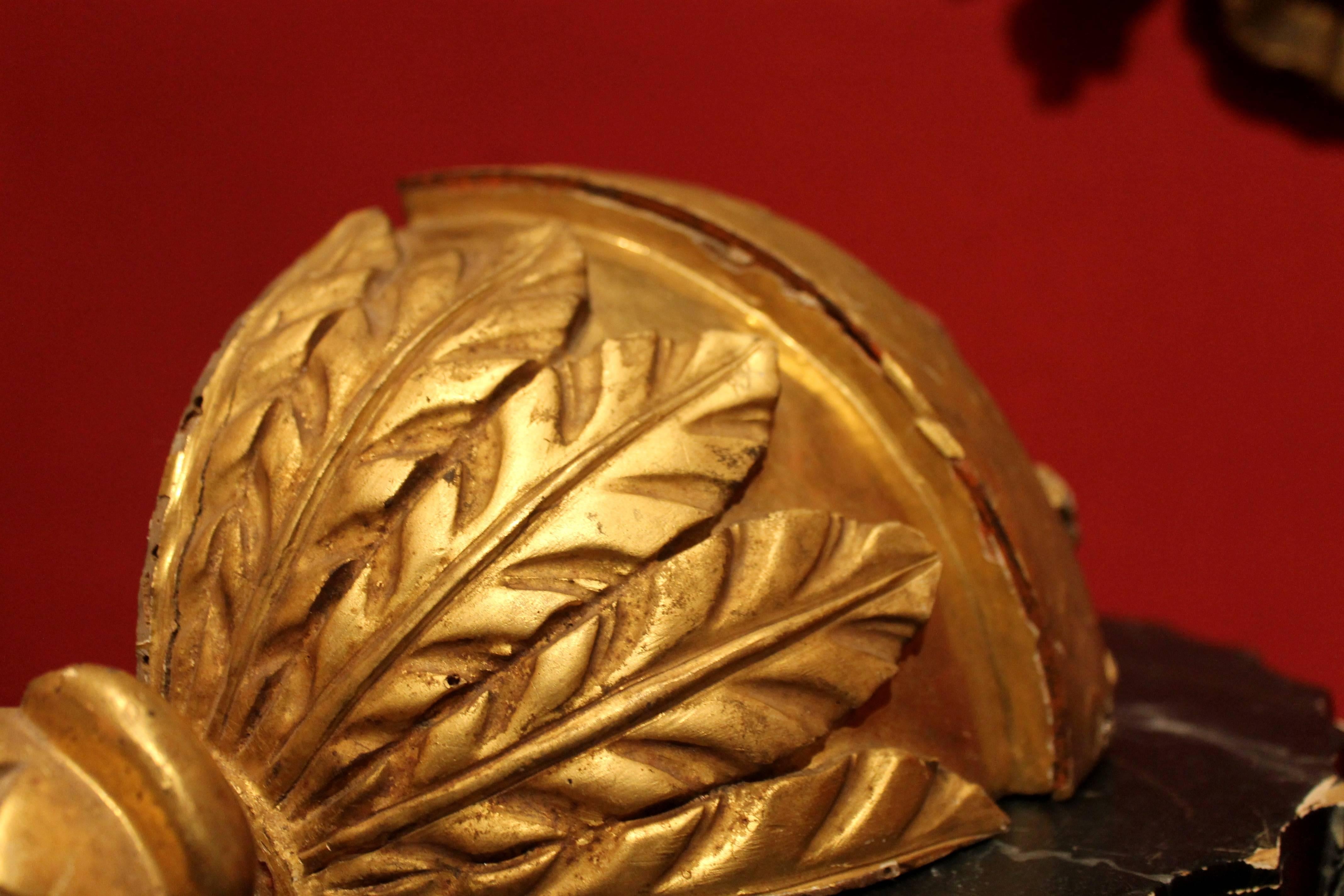 Une très belle paire d'appliques italiennes en bois doré sculpté à la main, datant de la période baroque du 17e siècle, réalisées avec la technique des feuilles d'or. La base d'angle est finement sculptée de feuilles d'acanthe avec un pin en finale
