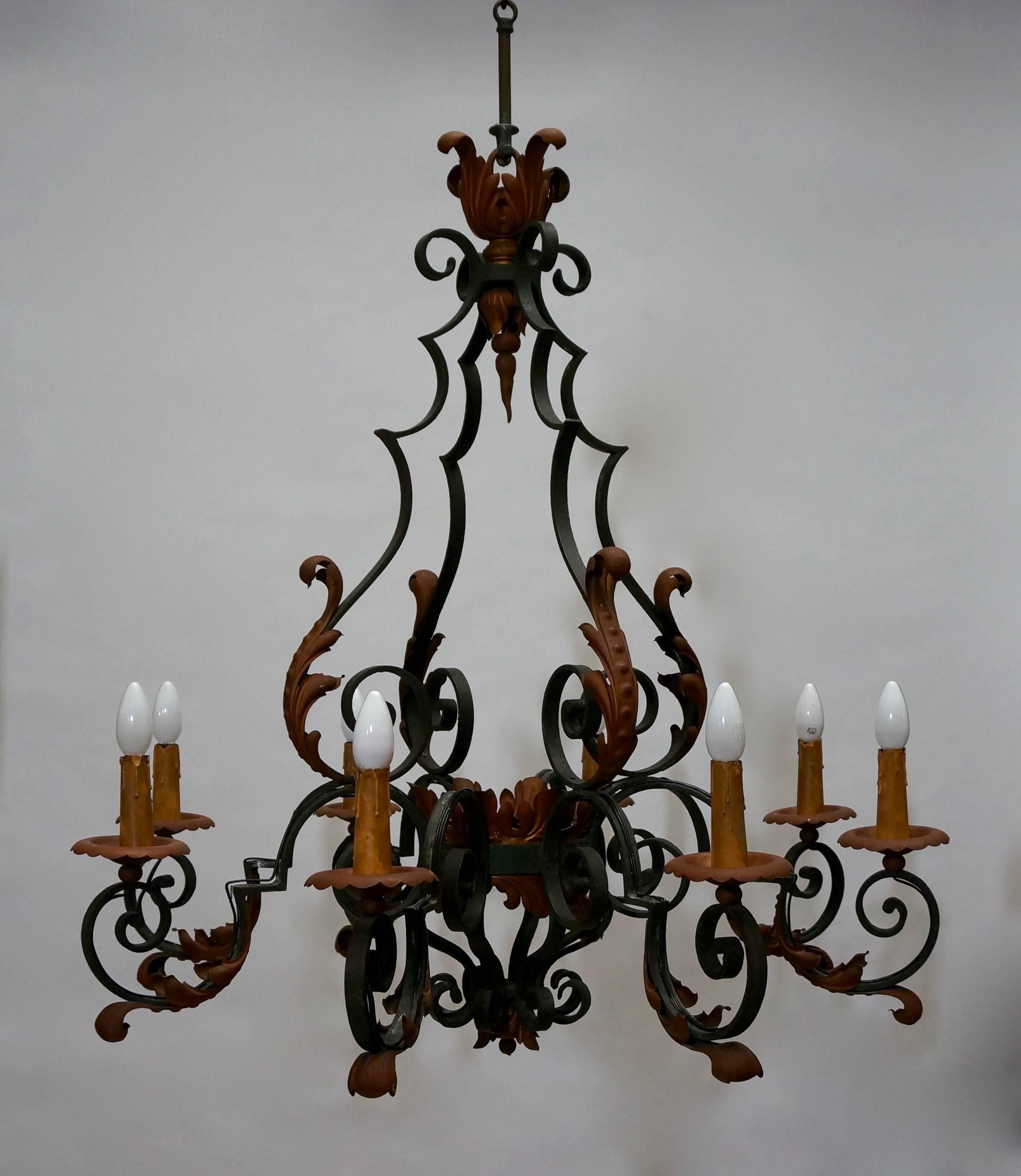 Handsome chandelier with handmade forged iron scrolled arms adorned by welded tole acanthus leaves. Painted in a green and copper color.