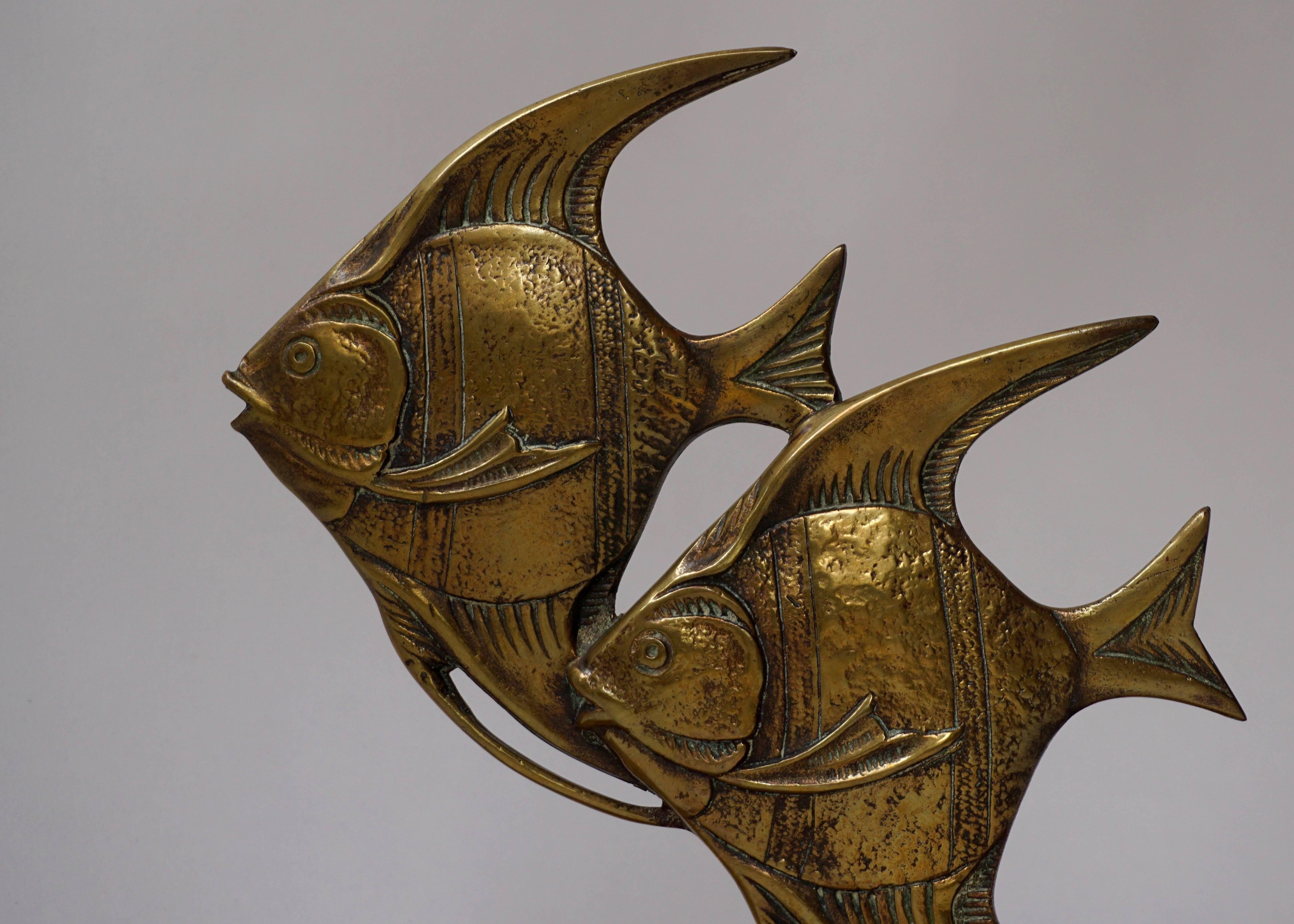 Brass fish sculpture on marble base.