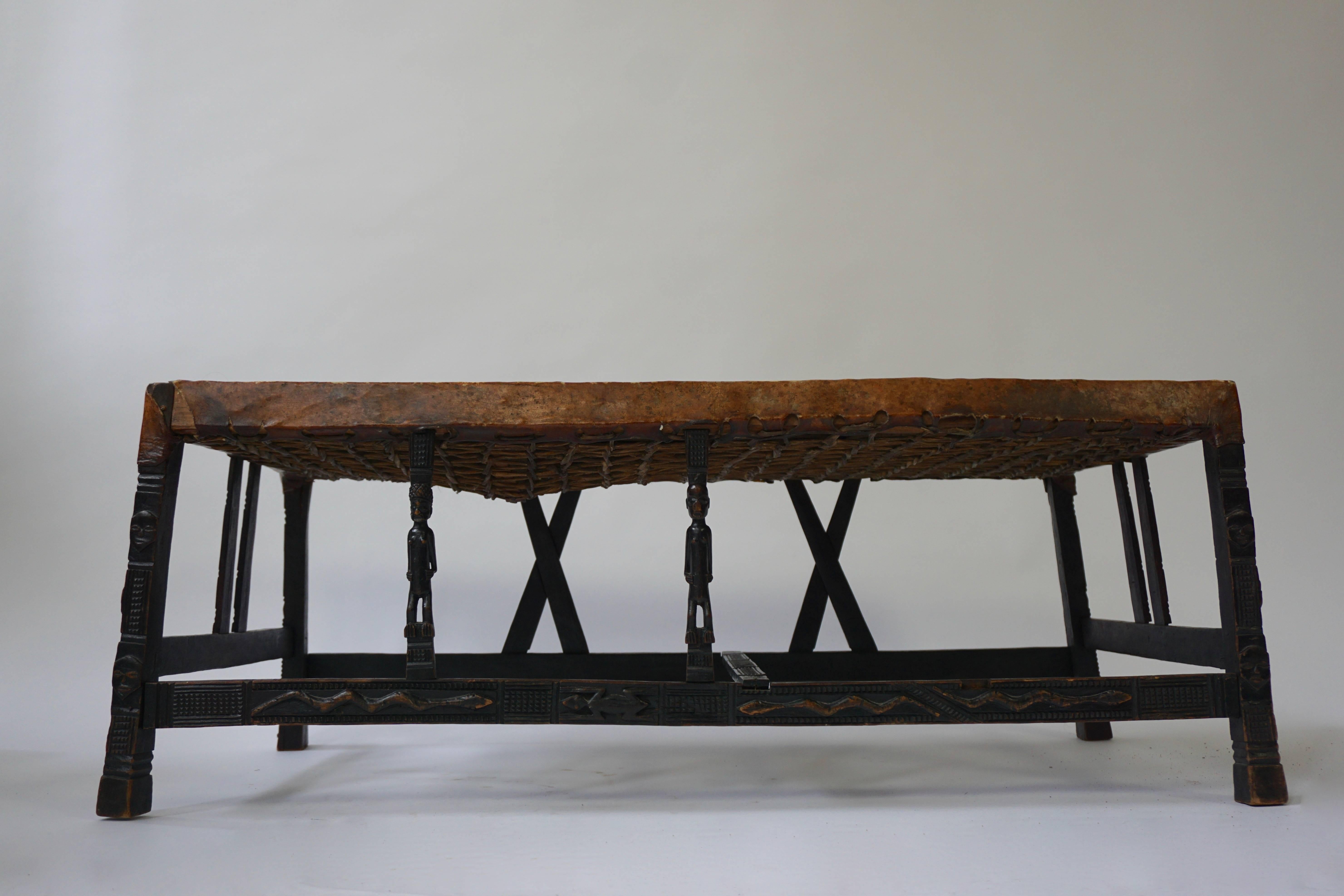 A fine and elegant hardwood Chokwe (Angola) bench, carved all-over with geometric patterns, human and animal motifs.
The front rain supported with caryatids in the form of male figures of which one is missing.
Original parchment cover,
late 19th