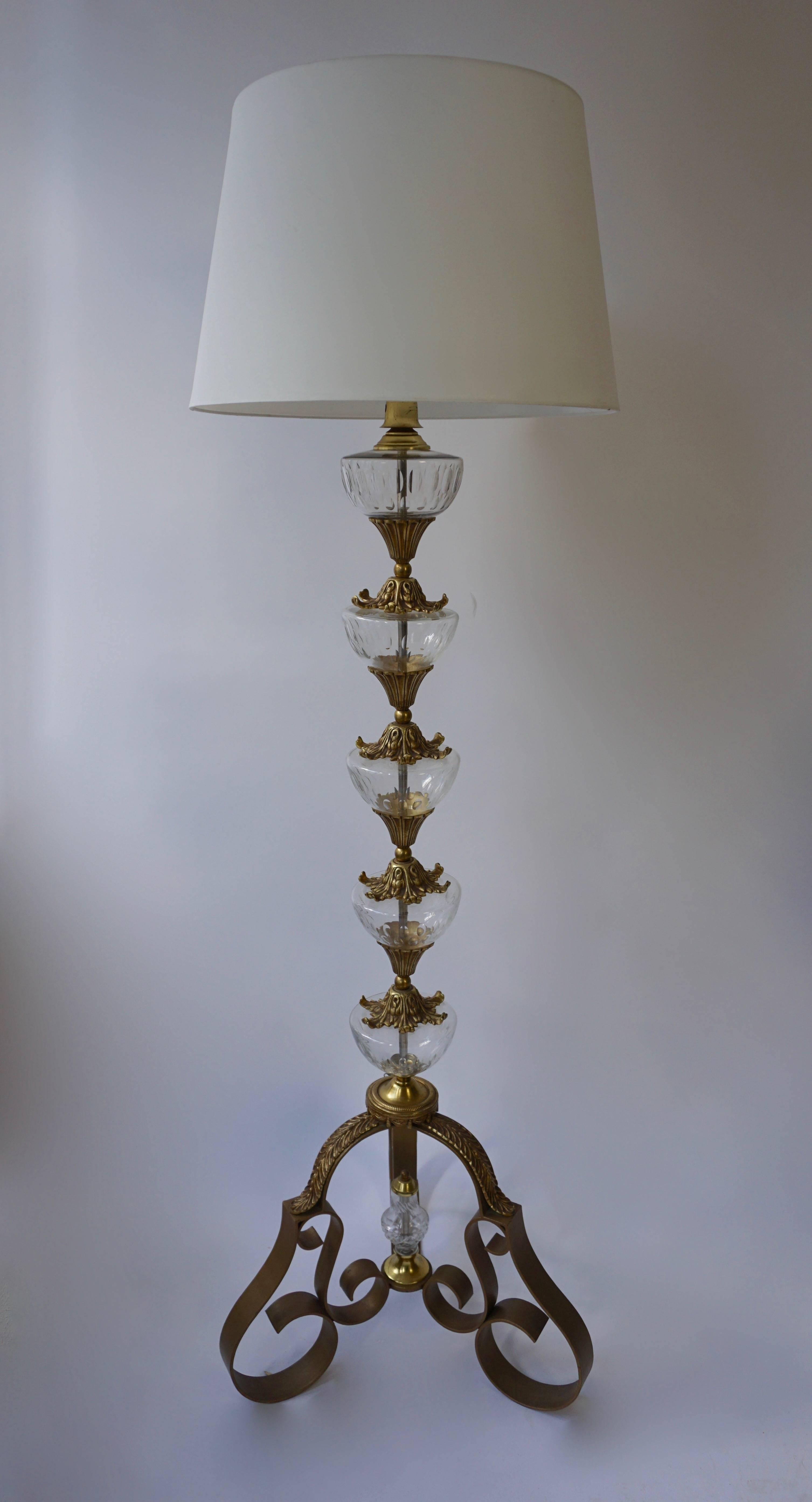 A rare and elegant lamp stand, resting on a wrought iron tripod foot with bronze palmette appliqués, the shaft composed of five cut crystal flat – top bowls linked together by bronze lambrequin ornaments,1940s.
Measures: Height lamp stand without