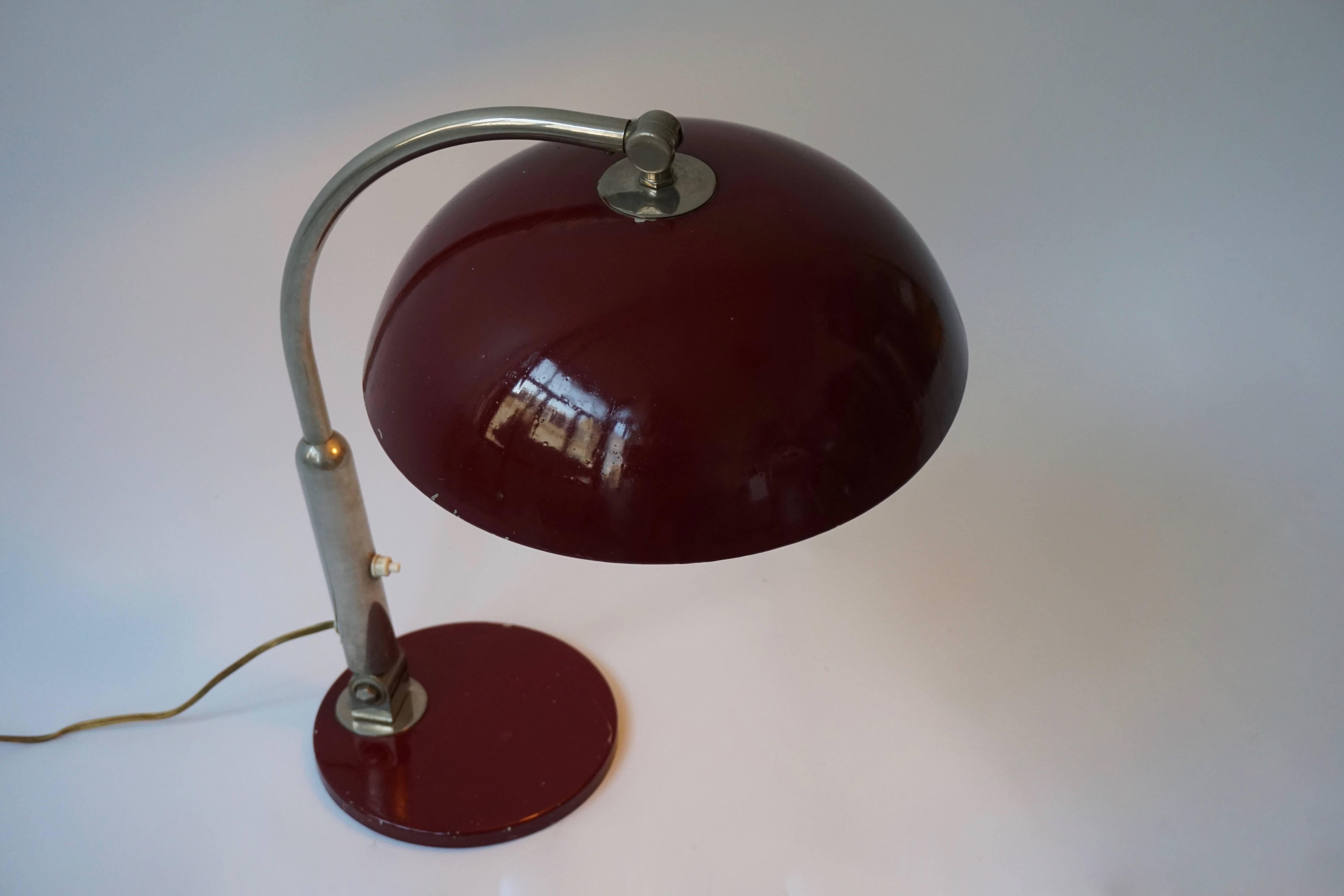 This Mid-Century Modern desk lamp features a red base and shade and a chromed arm. 
Both the arm and the shade are adjustable.