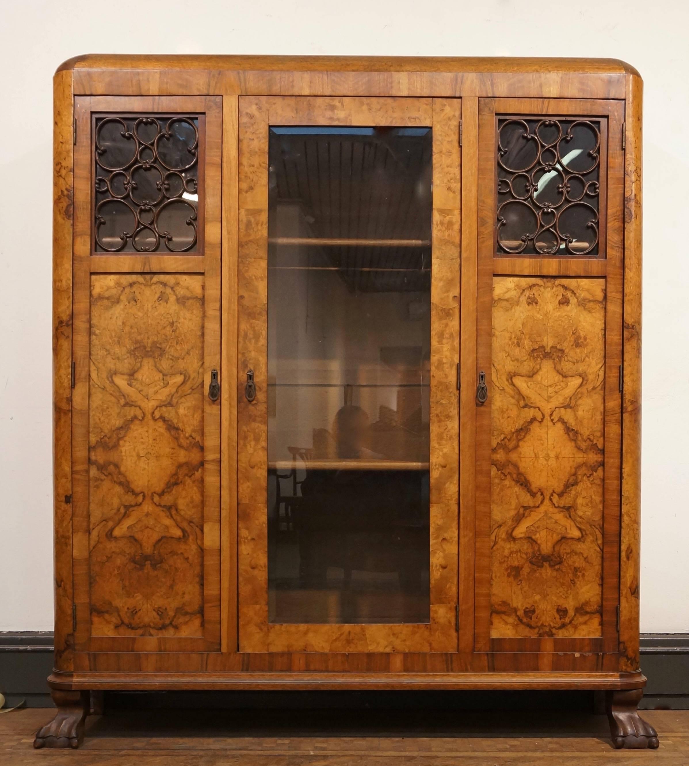 This beautiful walnut armoire features a central door front flanked by two doors, which open to shelved storage. (Two shelves).
 