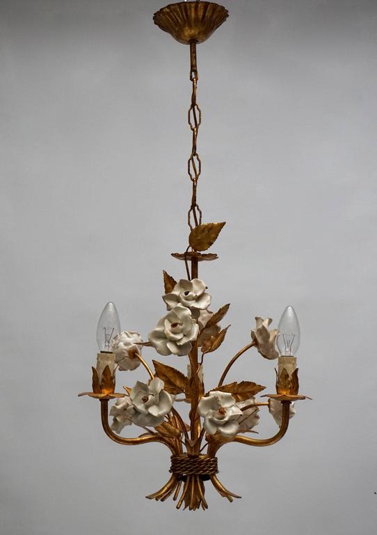 Two French gilt metal chandeliers with porcelain flowers.

Measures: 
Diameter 34 cm.
Height fixture: 44 cm.
Total height: 76 cm.