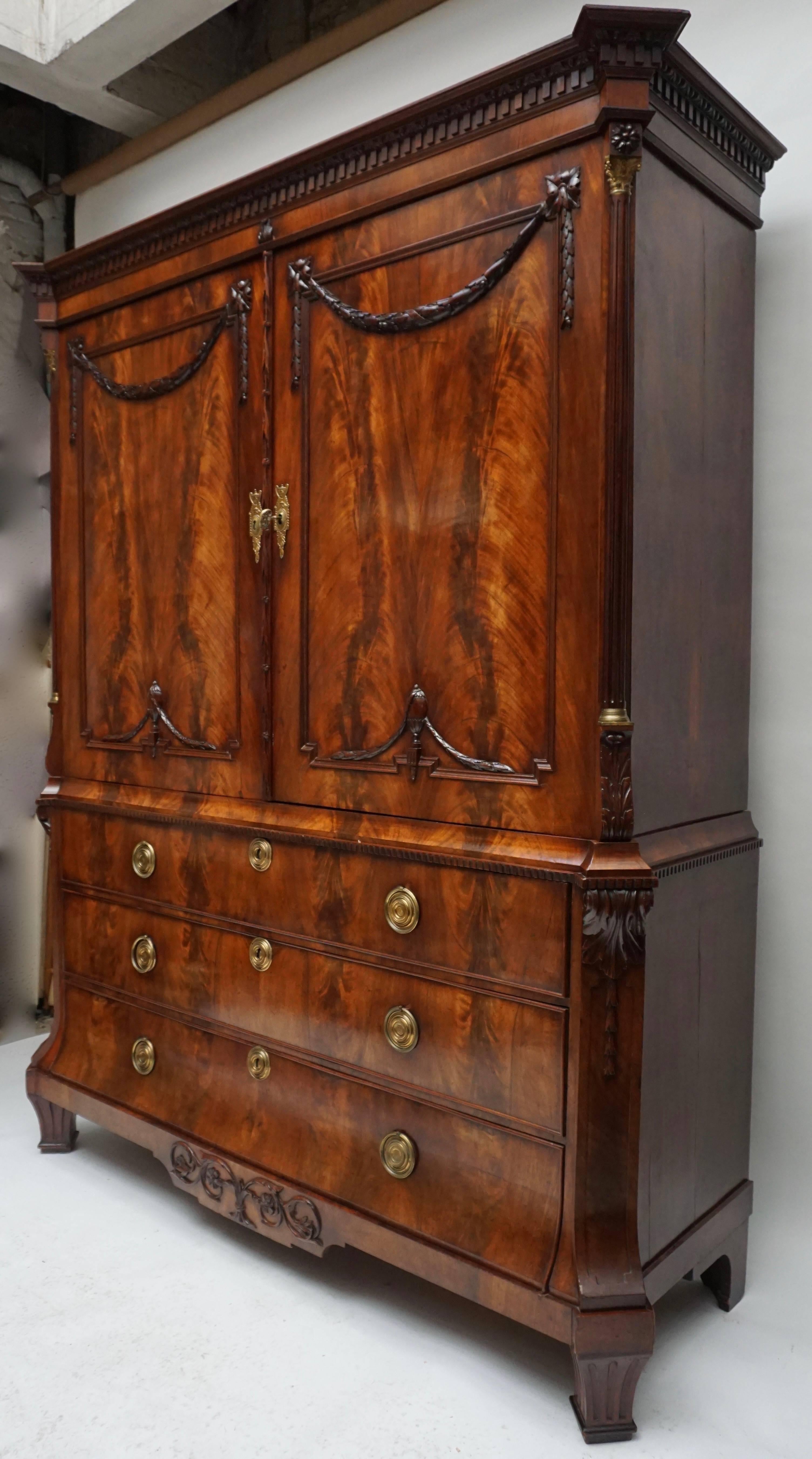 A magnificent mahogany neoclassical Dutch cabinet, the underpart with three graduated drawers under a pair of cupboard doors, the whole with chamfered corners with elegant reeded Corinthian columns in the upper part.
The doors are decorated with