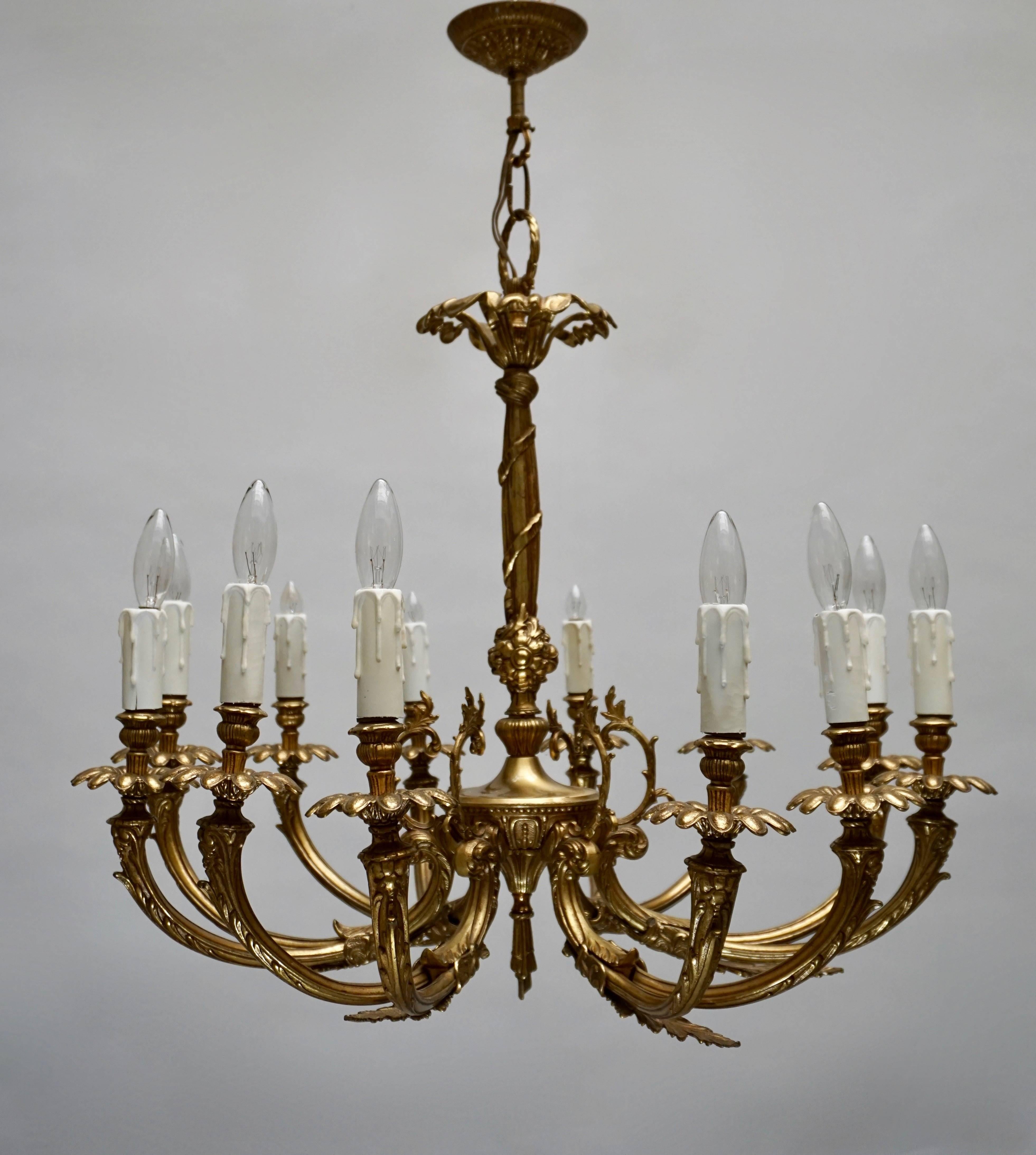 A French style 12-arm brass chandelier with cast leaves and floral decoration.

Diameter: 58 cm.
Height fixture: 65 cm
Total height with chain: 80 cm.
 