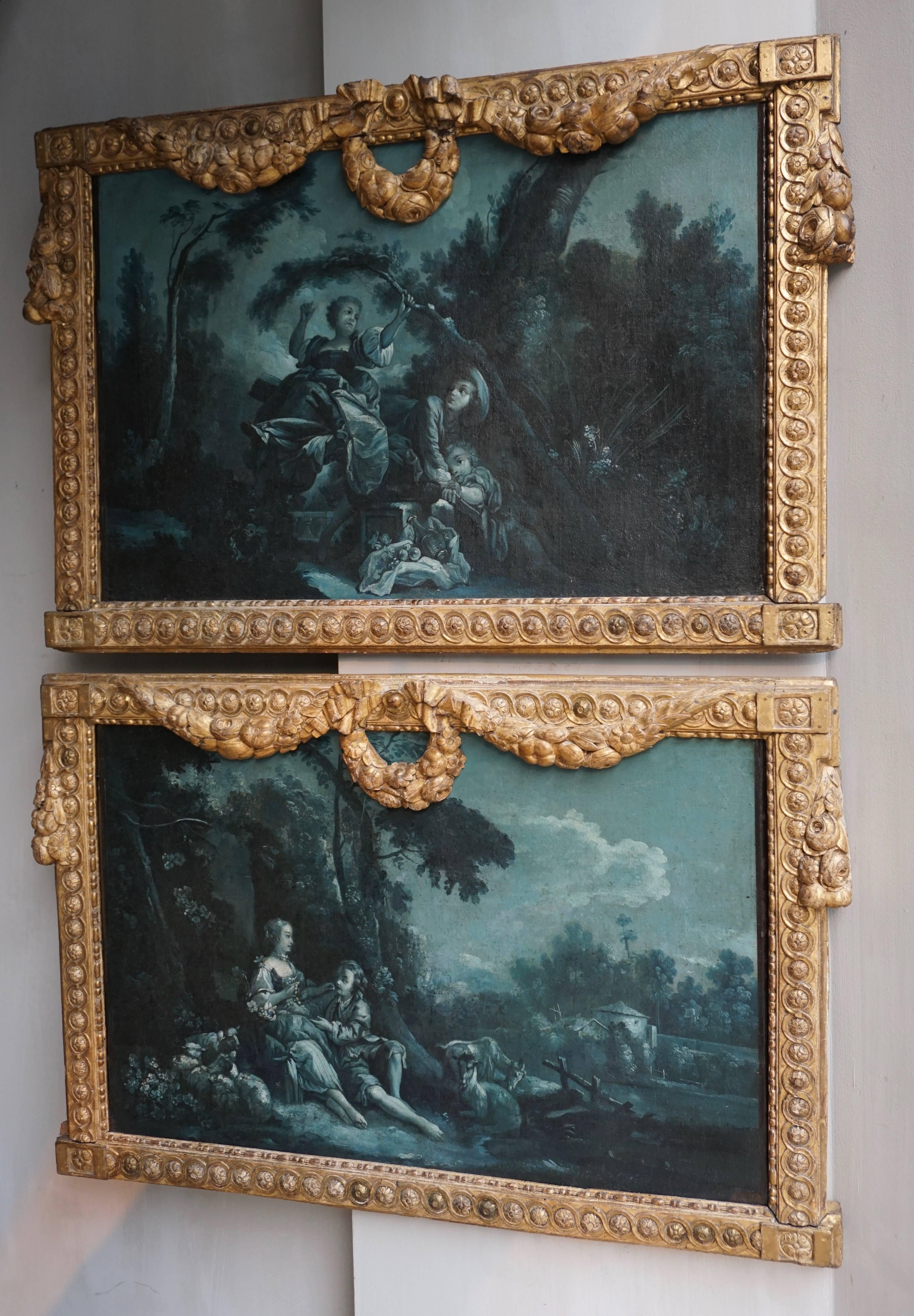 A very fine and rare pair of night blue grisaille overdoor paintings, oil on canvas; France, Louis XVI period, circa 1775.
Grisaille paintings are rarely painted in dark blue and these are surrounded by fabulous carved giltwood frames with garlands