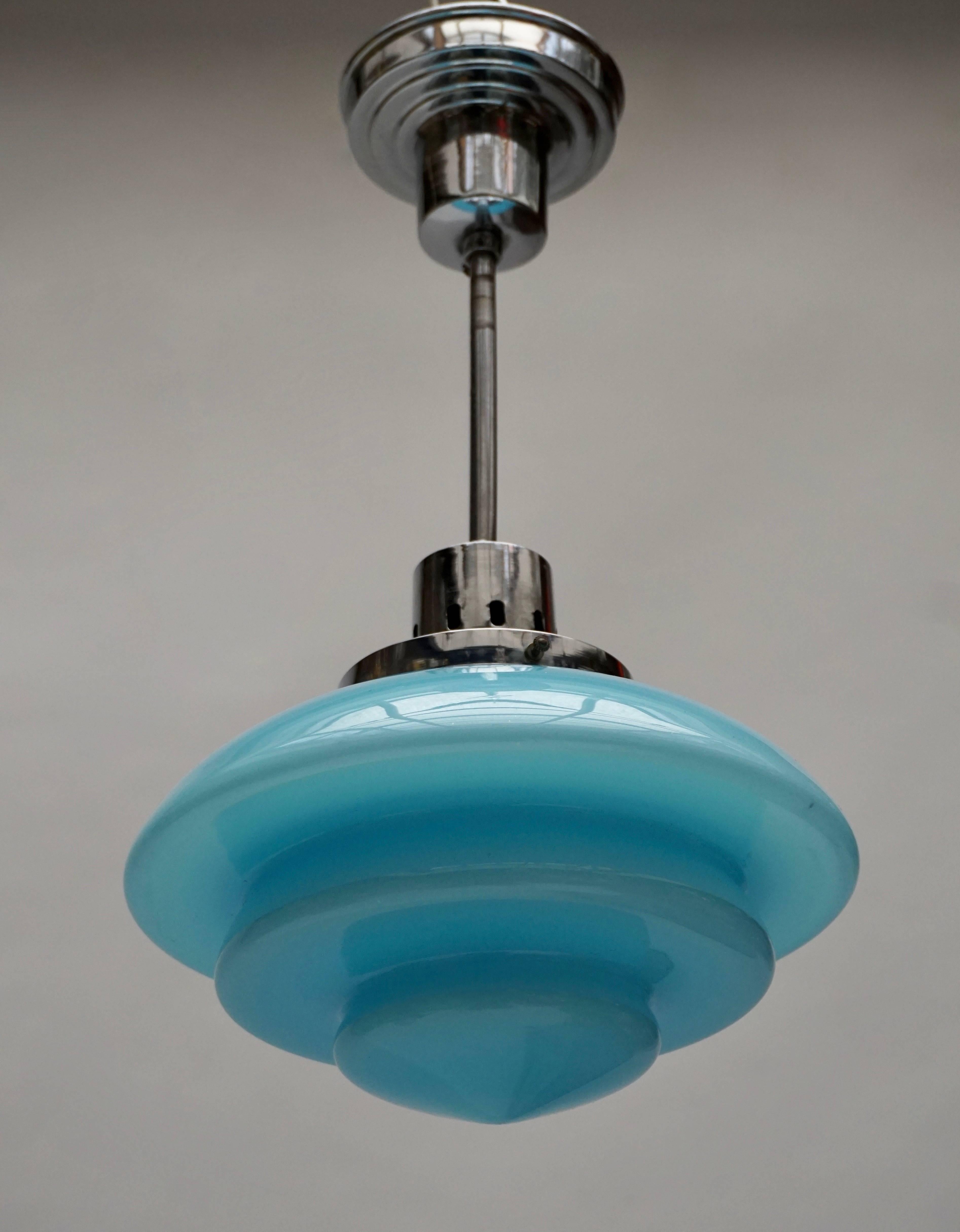 A pendant lamp in glass and by Paavo Tynell for Taito Oy, Finland ca. 1930's 

1930s Taito Art Deco Pendant Lamp
Materials: Chromed metal (iron and brass). Light blue hand blown crystal glass “opaline” opal diffuser. Brass and porcelain