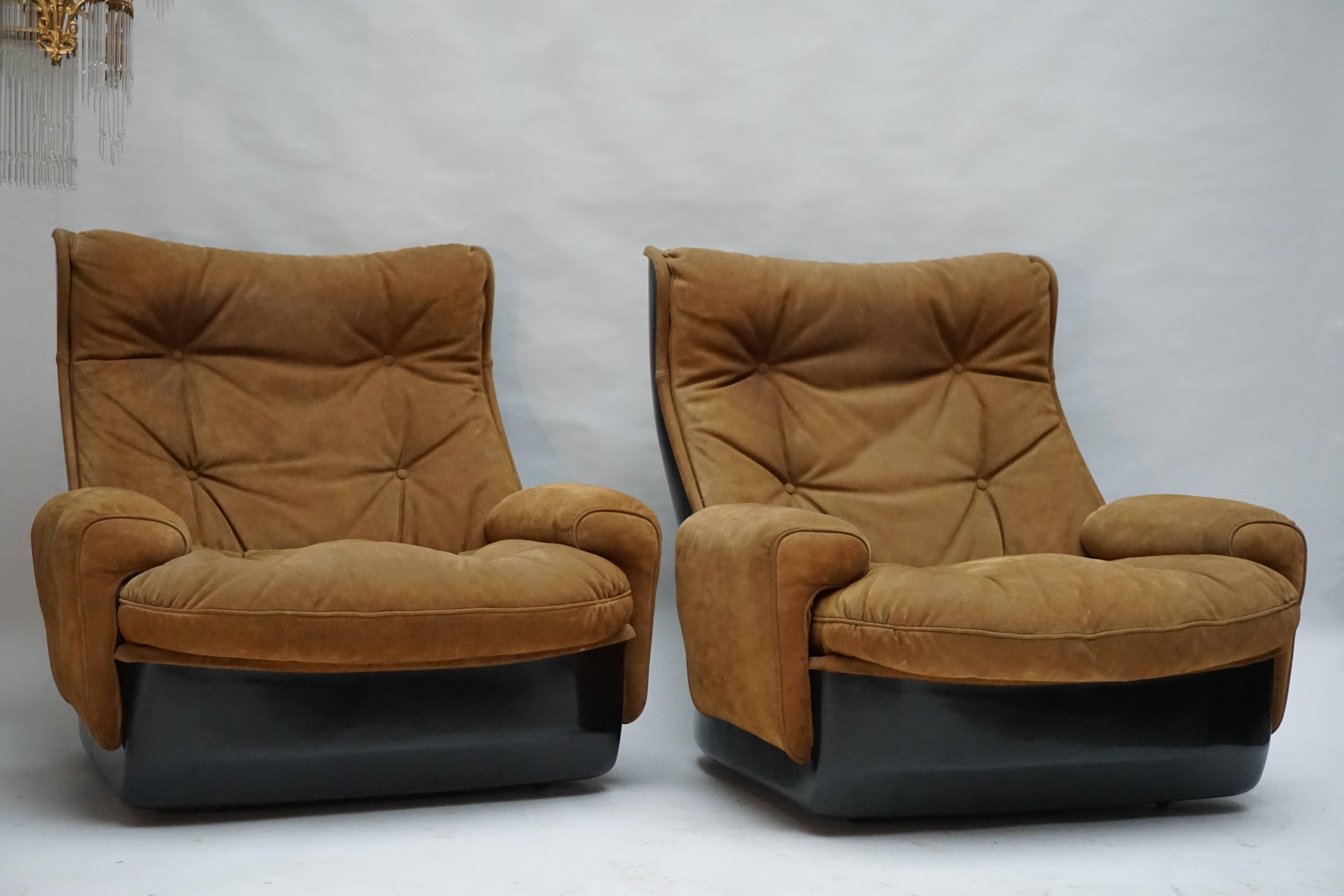 Two lounge armchairs on casters consisting by French manufacturer Airborne International. The shells are made from black fibreglass and the seating is covered in leather buttoned upholstery. This vintage set is in good condition and incredibly