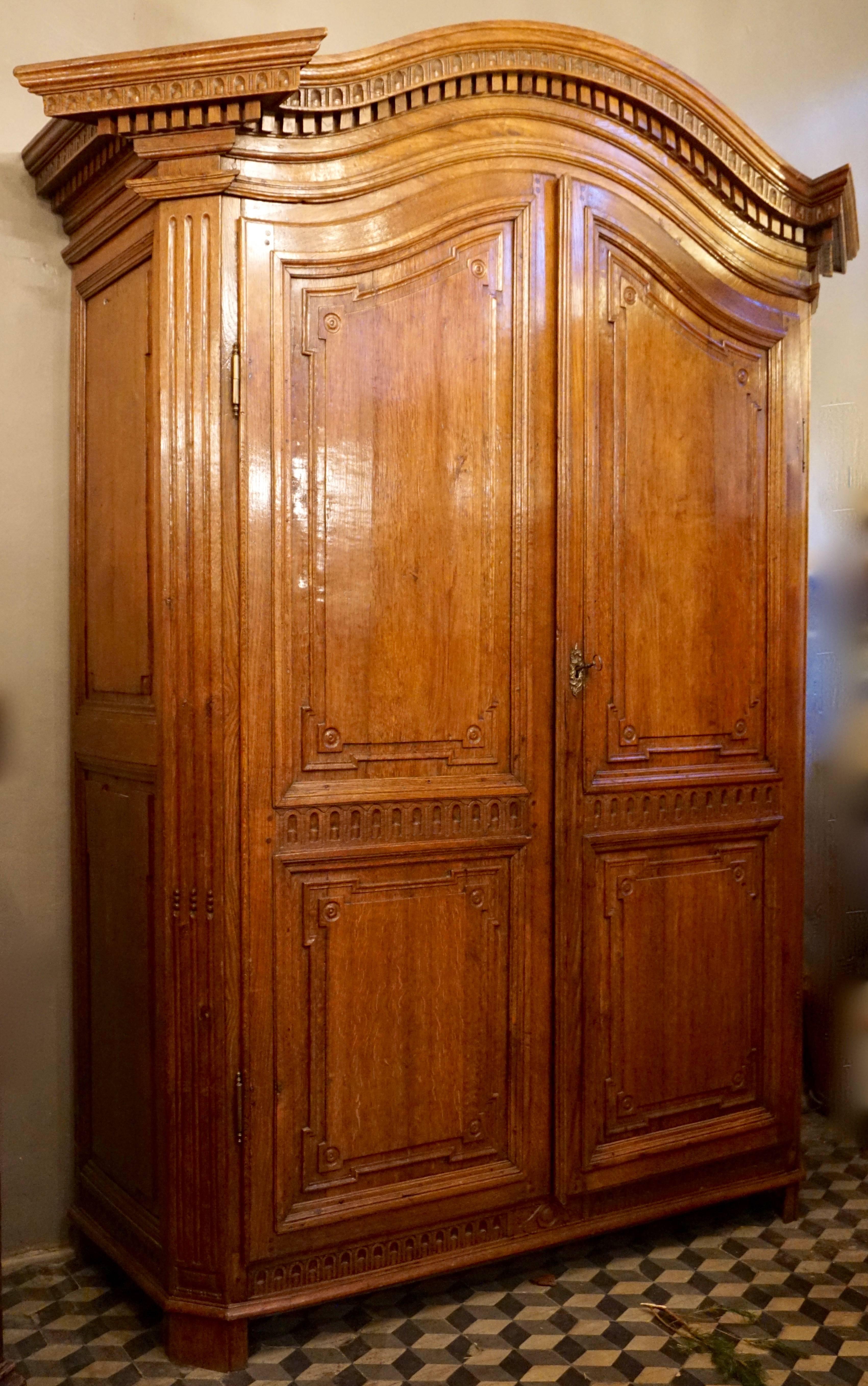 An elegant honey, colored oak armoire, Flemish, circa 1785.
With two richly moulded paneled doors and sides and a lovely ‘chapeau - de gendarme ‘corniche, standing proud from the cut-out corners and carved all-over in the Louis XVI style and of the