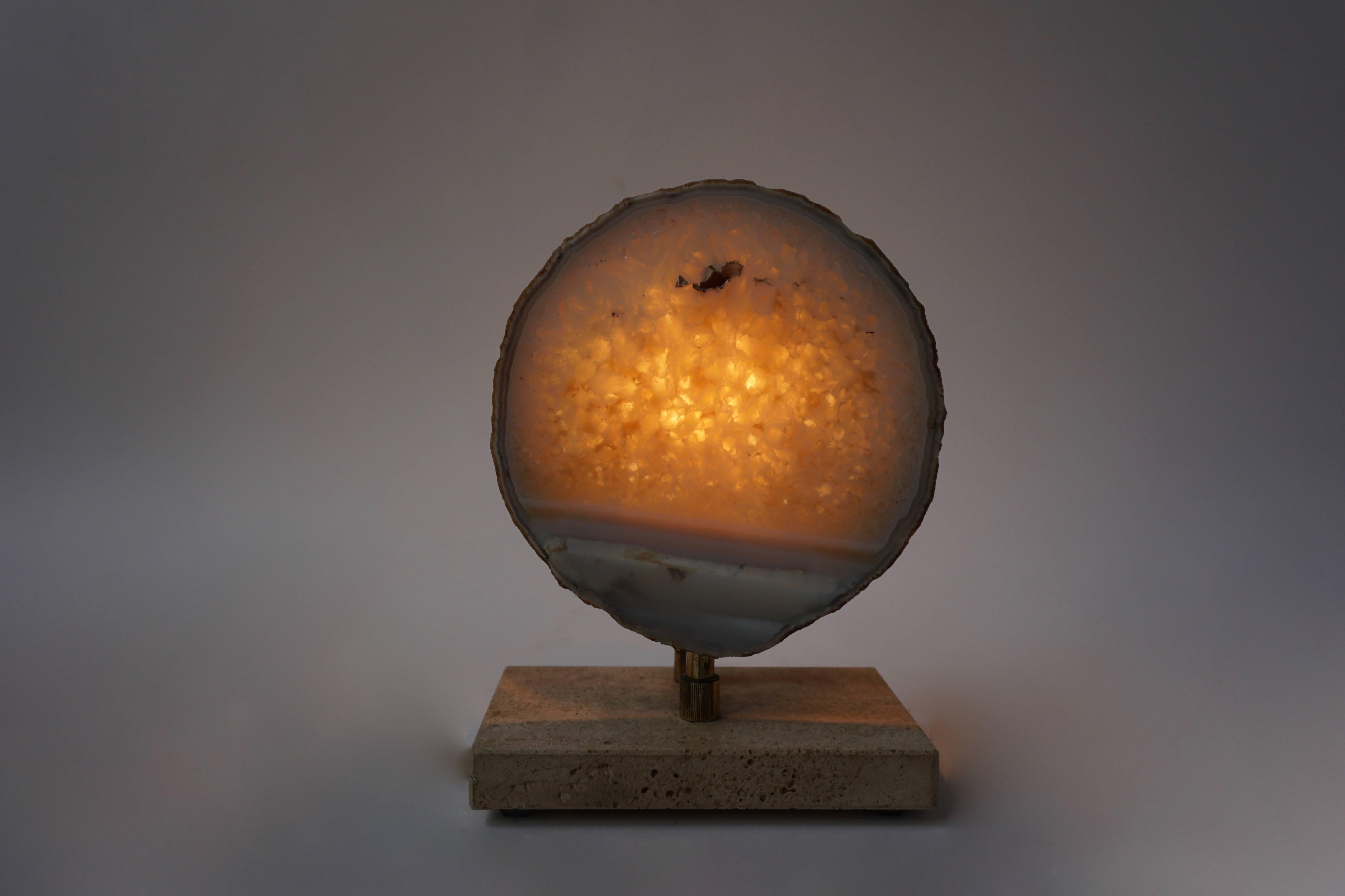Pierre Faveere Agate Table Lamp

Materials: Rectangular travertine, limestone base. Some brass parts and rod. Round slice lampshade, made of a densely grown agate geode, probably from the quarries around Idar-Oberstein in Germany. Yellow, white,