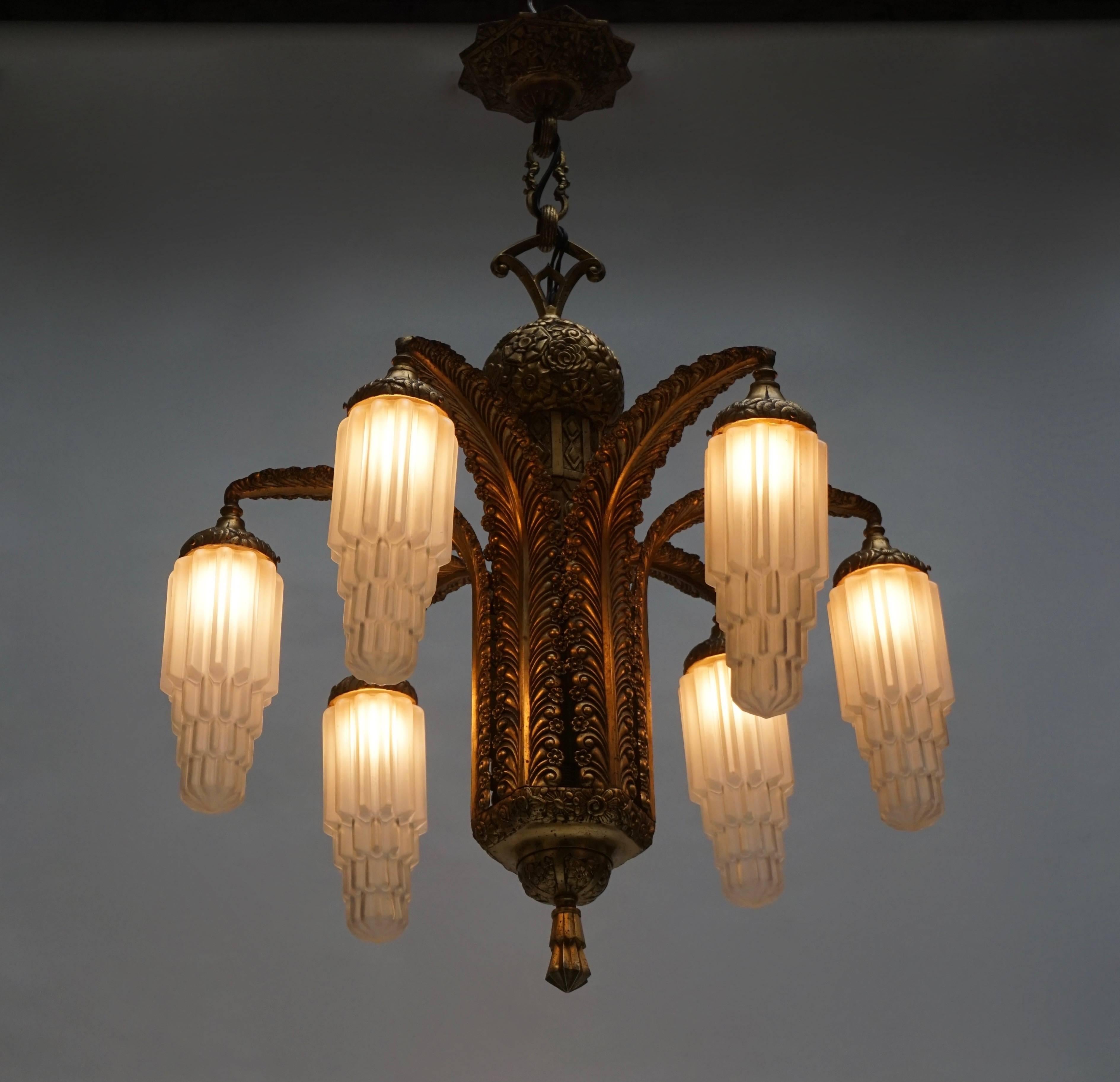 A very fine Art Deco bronze and glass six - light chandelier, in the manner of Edgar Brandt, circa 1925.
Measure: Diameter 72 cm.
Height fixture 80 cm.
Total height with the chain 100 cm.
Six E27 bulbs.
 