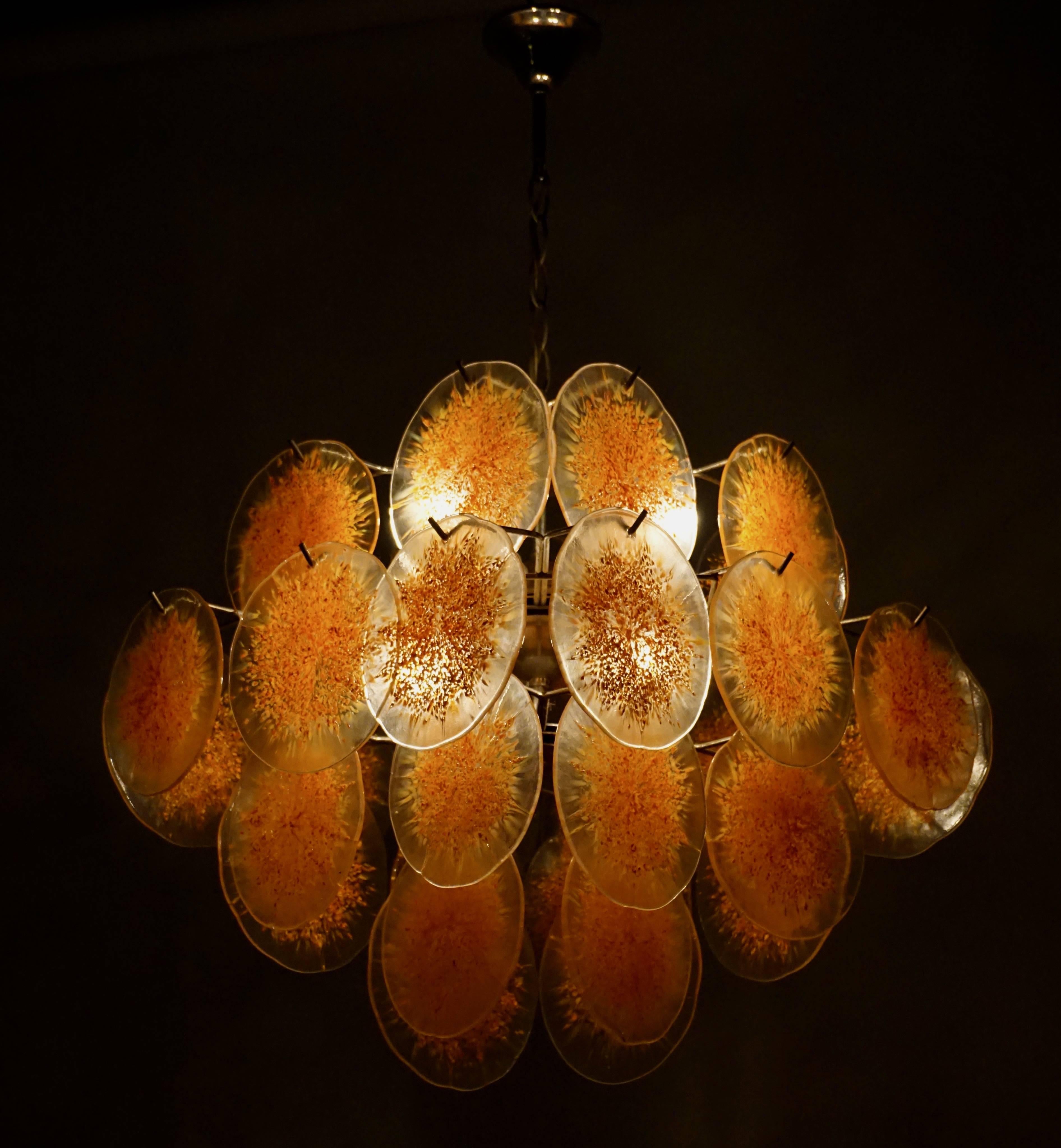 Italy,
1960 - 1970.
Wonderful created Vistosi light with very large glass discs. The chandelier has a very 'fresh look' due to the clear orange glass discs. These glass discs are hand produced which gives a superb light partition. This handcrafted