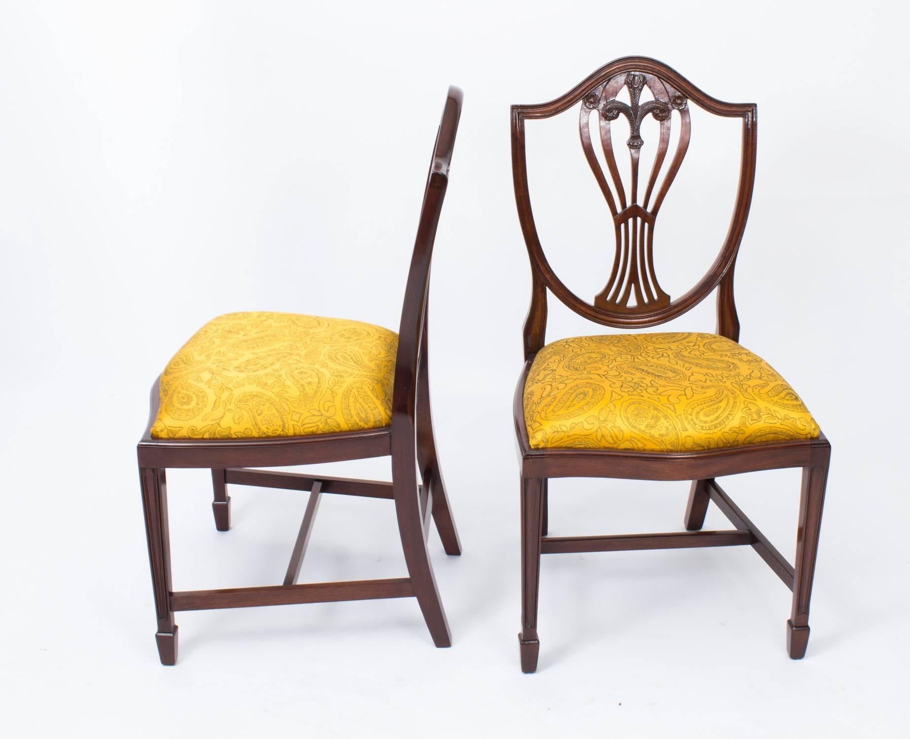 An absolutely fantastic English made set of ten Hepplewhite style Shield Back dining chairs, dating from the mid-20th century.

These chairs have been masterfully crafted in beautiful solid mahogany with hand-carved decoration throughout and the