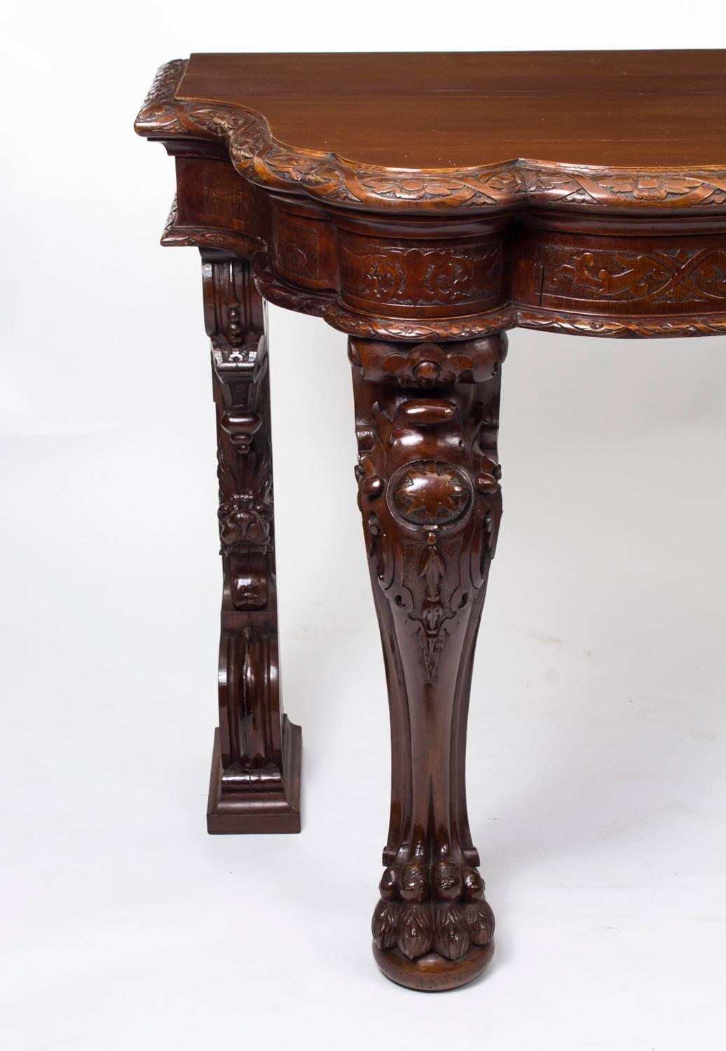 This is a superb antique Victorian mahogany serving table, circa 1870 in date.

This stunning serving table is made from solid mahogany and has a beautiful hand-carved rosette and ribbon border, which is repeated on the frieze, with a central heavy