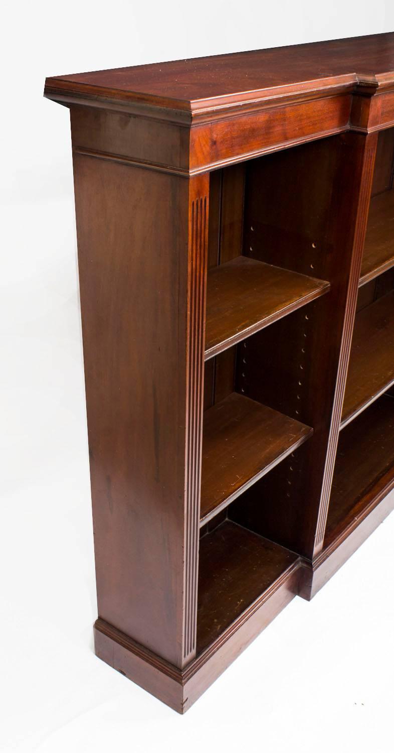 This is a beautiful antique Edwardian mahogany open breakfront bookcase, circa 1900 in date. 

The top and skirt have a decorative moulded edge which is supported by reeded sides with an inverted breakfront centre.

Each section is fitted with