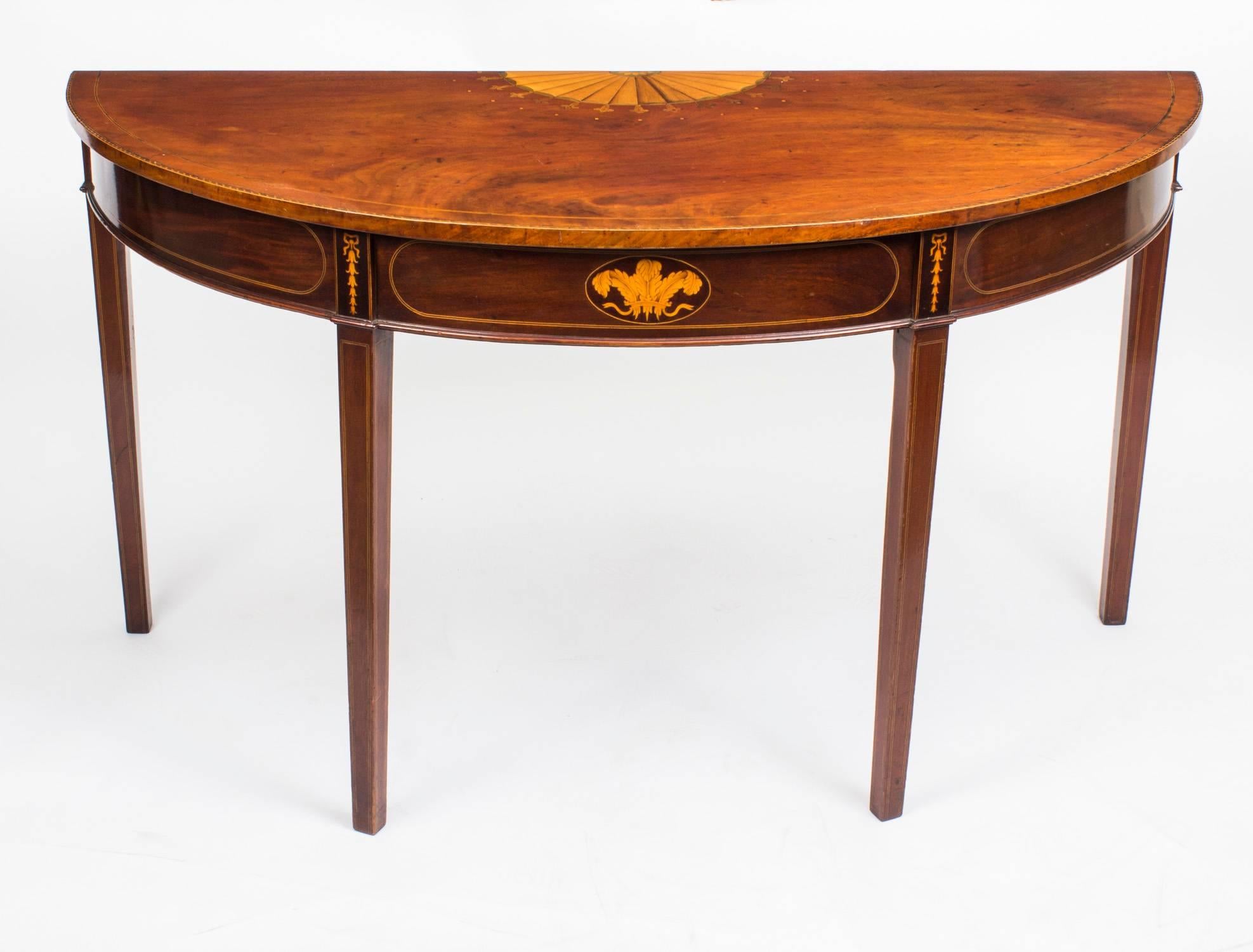 This is a beautiful antique George III flame mahogany demi lune console table, circa 1800 in date.

It features a beautiful boxwood and ebony chequered strung inlaid top with further inner double stringing. The rear has a central inlaid boxwood