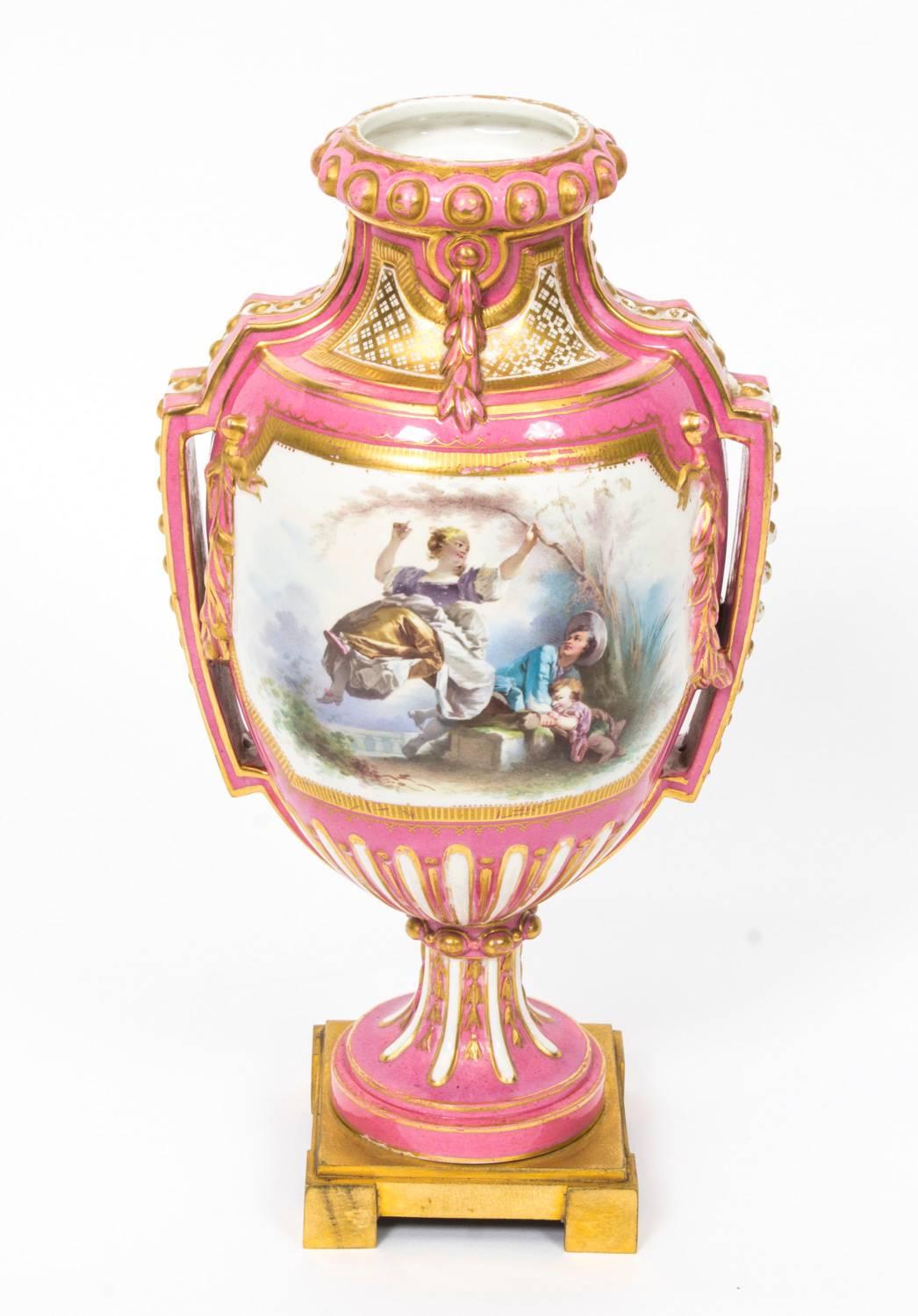 This is a beautiful antique pair of French Sevres porcelain and ormolu-mounted vases and covers, circa 1880 in date.

They are superbly decorated with hand painted panels of flowers and scenes of courting couples, after Boucher, on pink gilde