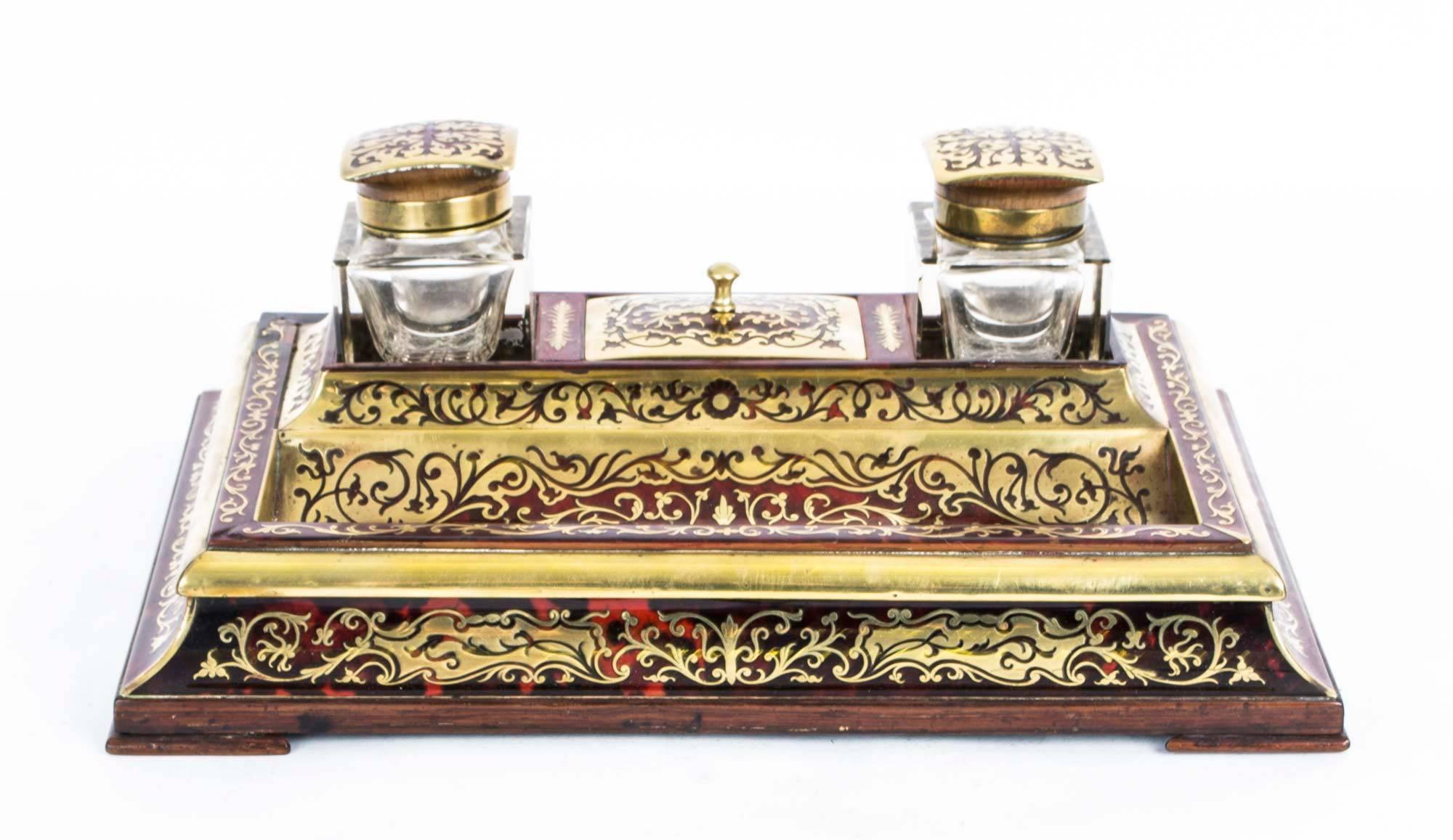 This is a lovely antique French ebonised cut brass Boulle work encrier, circa 1840 in date and retailed by the eminent retailer J.C. Vickery, of Regents Street, London.

The encrier comprises two glass inkwells and a lidded stamp box with a sunken