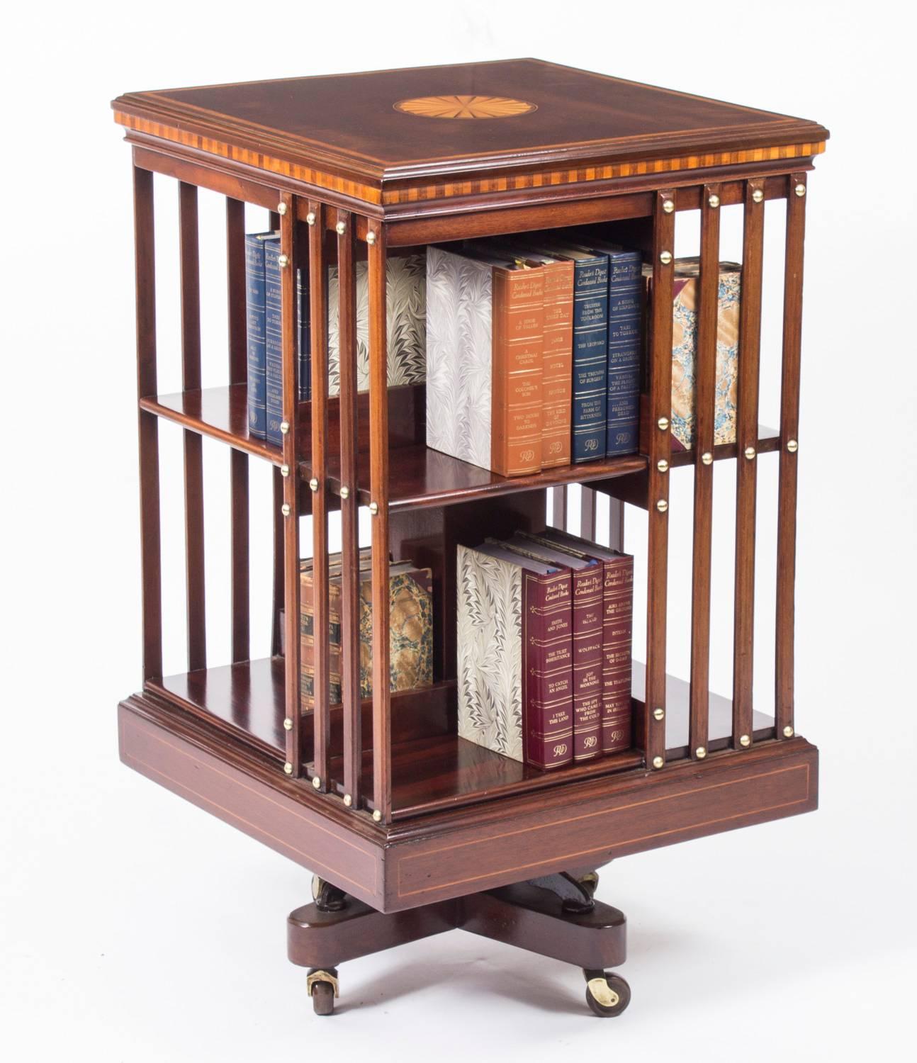 This an exquisite antique revolving bookcase attributed to the renowned retailer and manufacturer Maple & Co., circa 1890 in date.

It is made of mahogany , revolves on a solid cast iron base, has inlaid boxwood lines to the top and bottom, the top