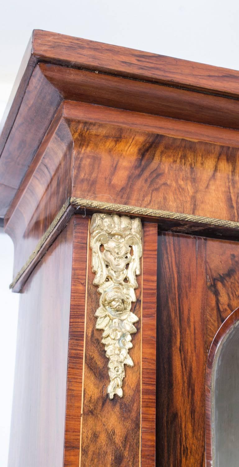 This is a stunning antique burr walnut and inlaid bookcase or display cabinet, made circa 1860 in England.

It has been crafted from the most beautiful burr walnut, and has elegant inlaid decoration.

It has two glazed doors on top, for displaying