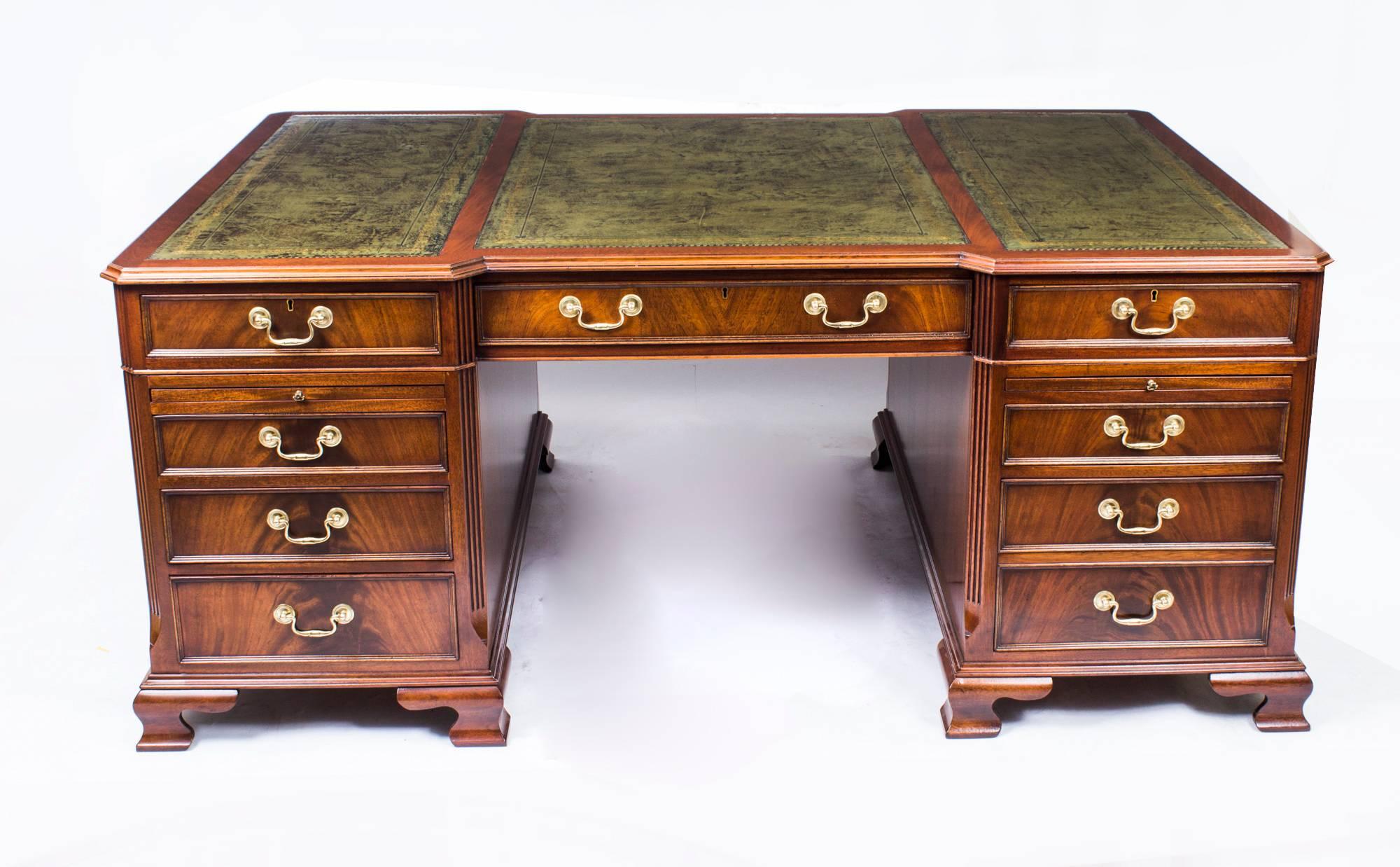 This is a stunning large vintage Georgian style partner’s desk, masterfully crafted in flame mahogany, dating from the second half of the 20th century.

The desk top has a beautiful three part green gilt tooled leather writing surface and it is