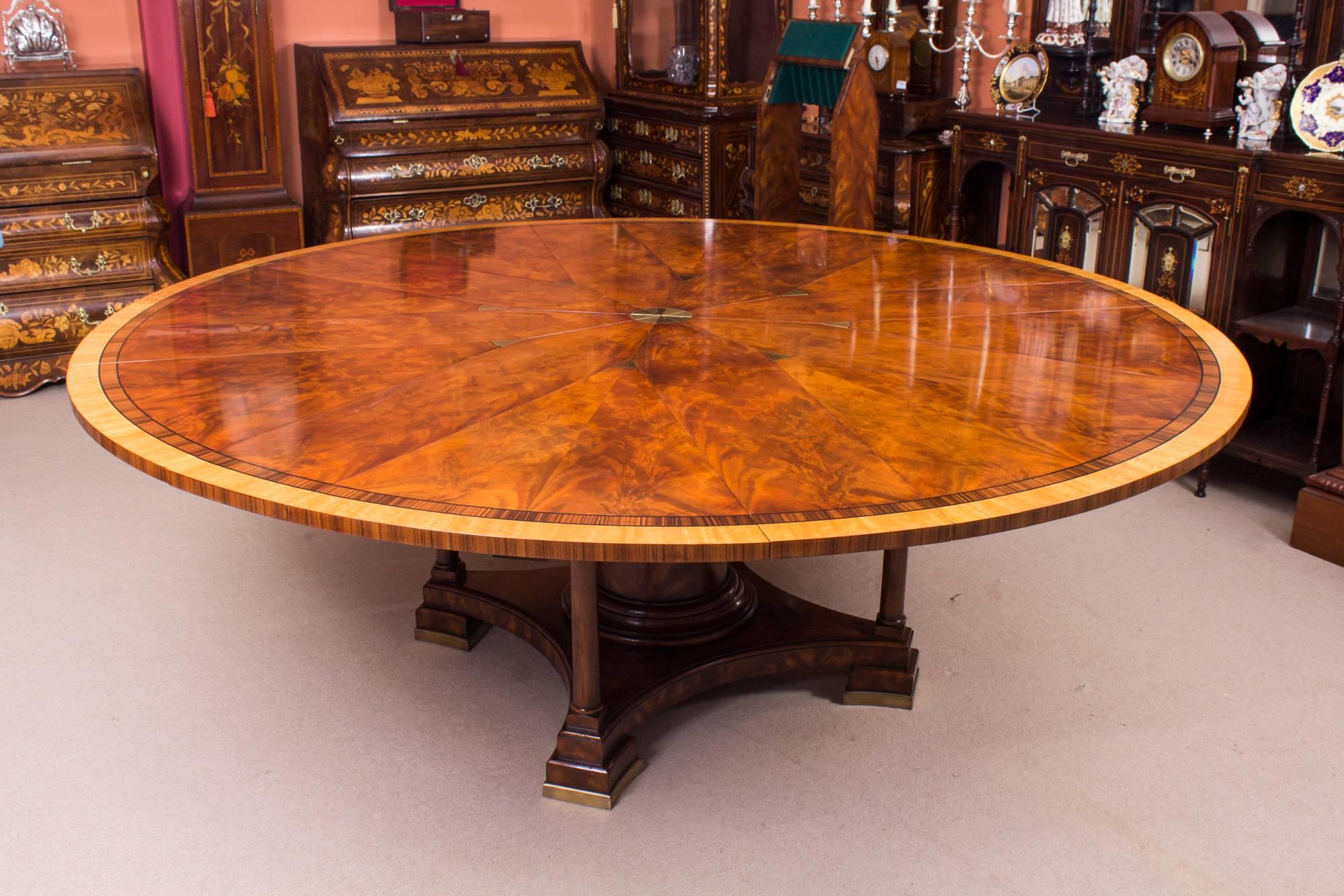 This is a beautiful Theodore Alexander replica of Robert Jupe's flame mahogany extending dining table with a matching set of ten bar back dining chairs, dating from the last quarter of the 20th century.

The brass capstan action rotating eight