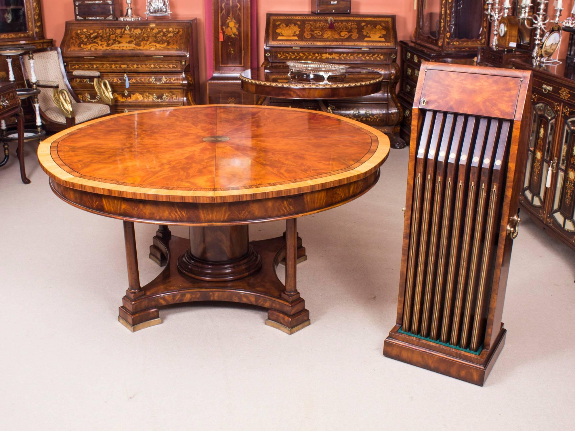 This is a beautiful Theodore Alexander replica of Robert Jupe's flame mahogany extending dining table, dating from the last quarter of the 20th century.

The brass capstan action rotating eight triangular segments to accommodate eight additional