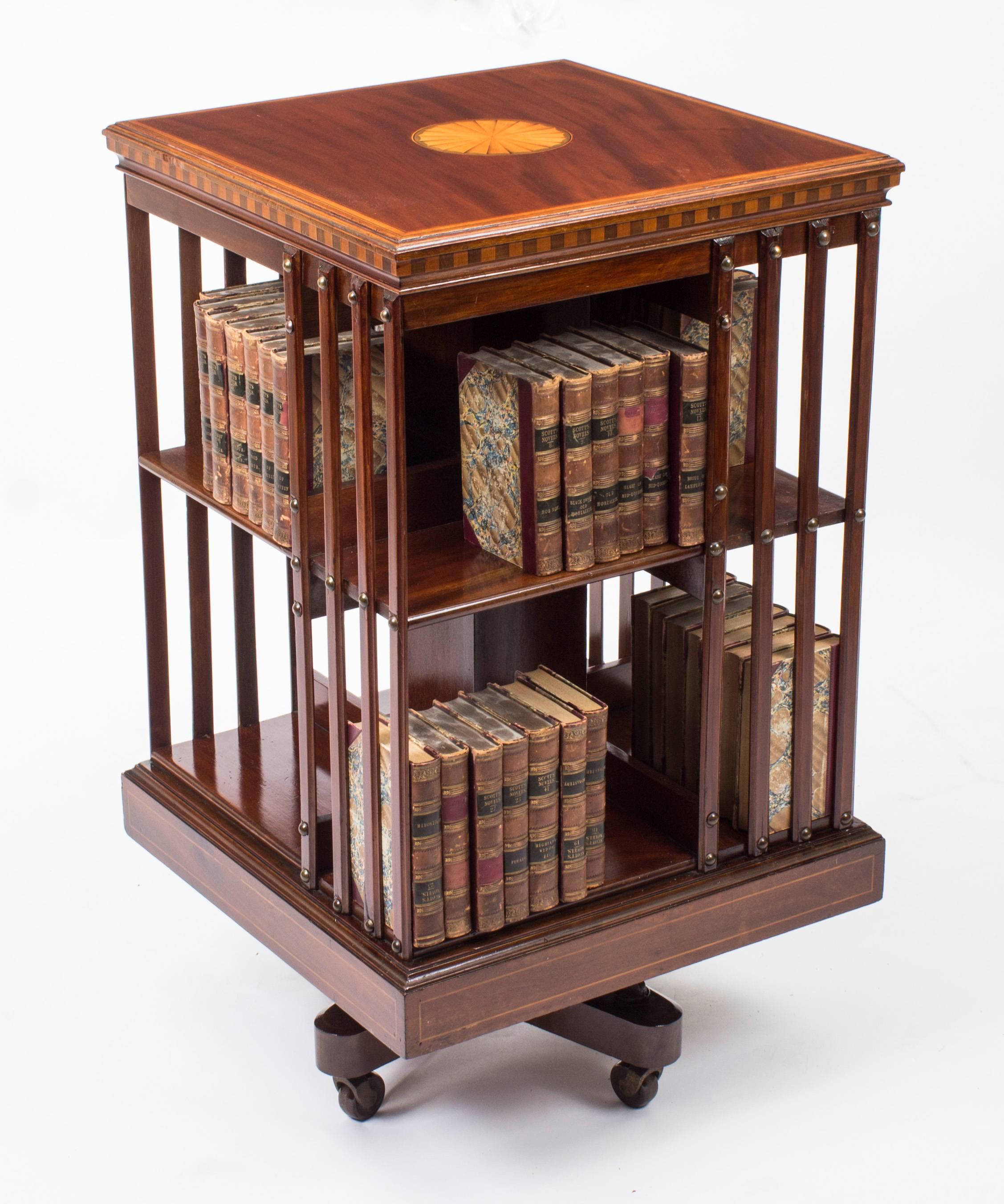 This an exquisite antique revolving bookcase attributed to the renowned retailer and manufacturer Maple & Co., circa 1900 in date.

It is made of mahogany, revolves on a solid cast iron base, has inlaid boxwood lines to the top and bottom, the