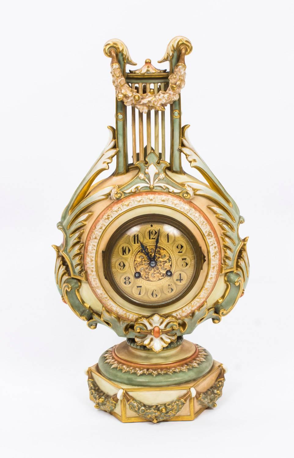 This is a truly exquisite and rare late Victorian Royal Worcester blush porcelain lyre cased mantel clock, dated 1900.

The gilded dial set within a beautiful foliate wreath and raised on a decorative octagonal platform base, the No.1385 is